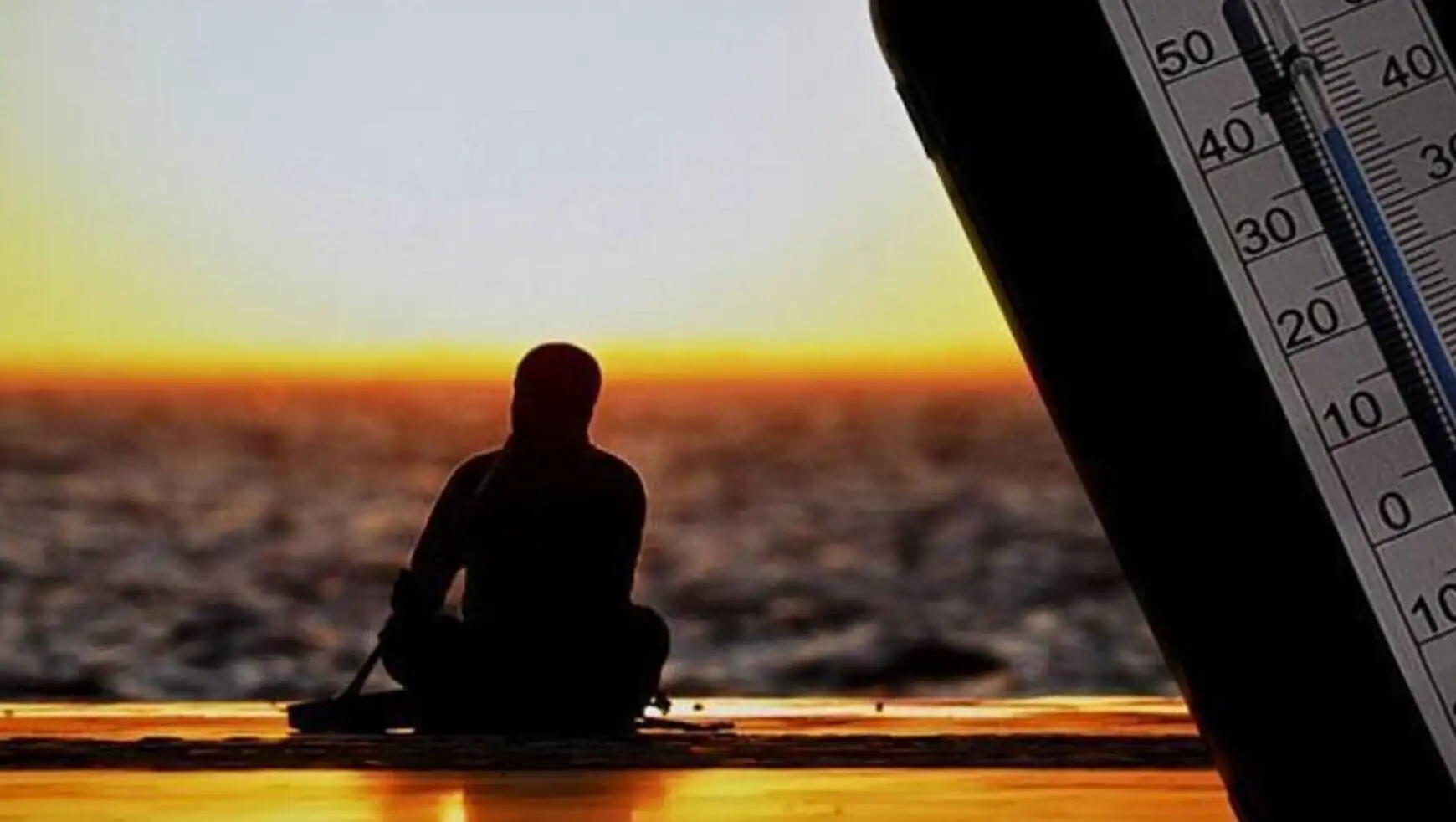 A person sitting on a dock with a guitar in the back A person sitting on a dock with a guitar in the back