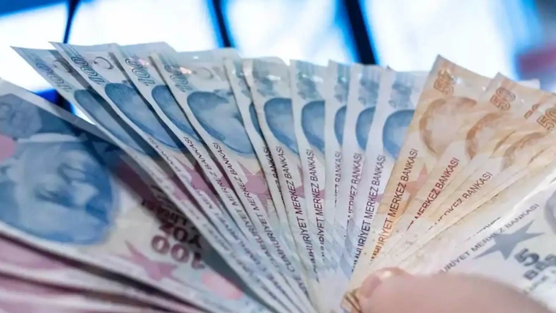 A hand holding a fan of currency.