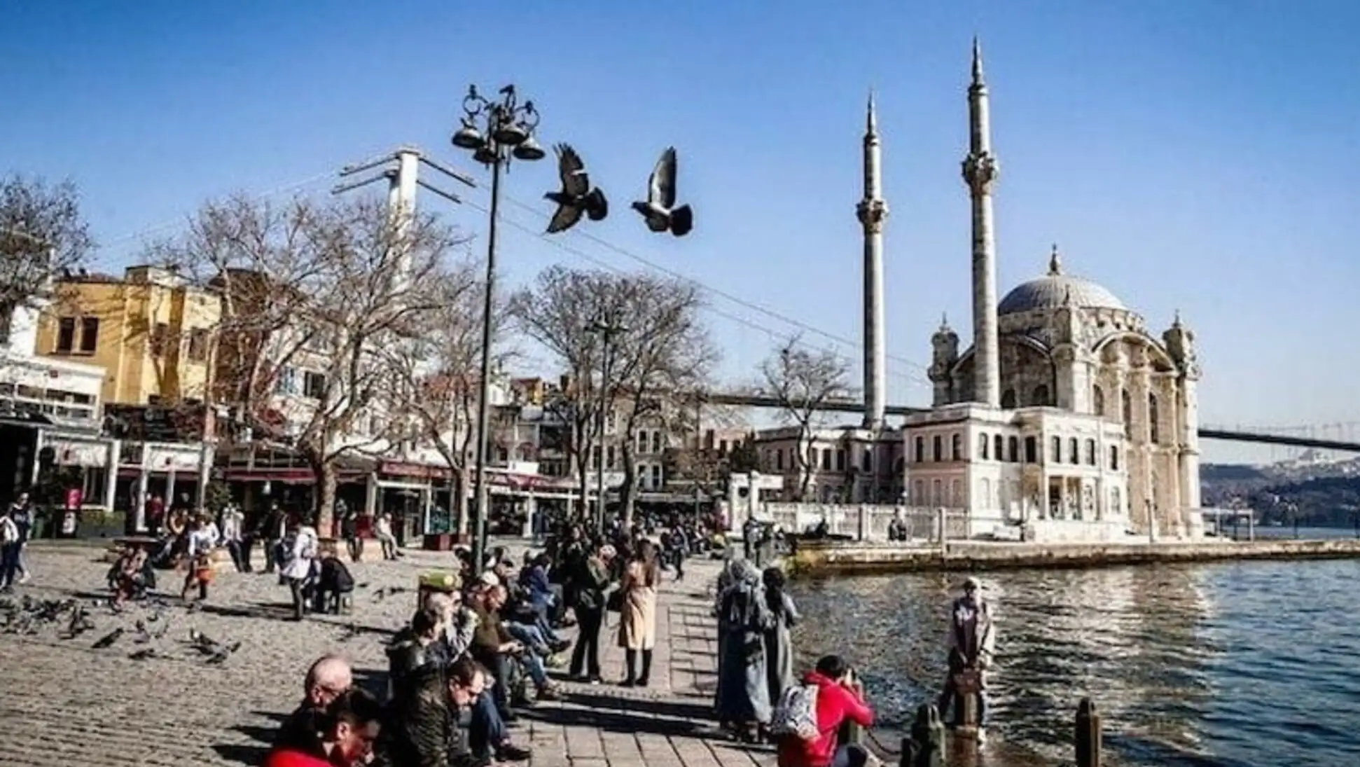 A group of people sitting by the water in Istanbul.