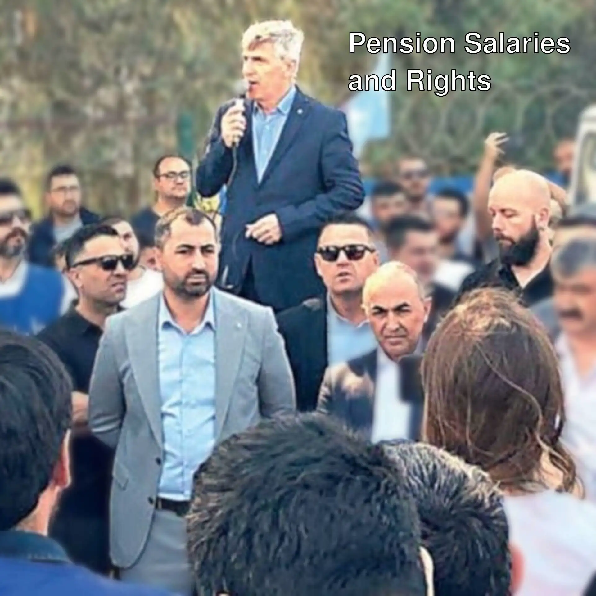 A man speaking into a microphone in front of a crowd of people.