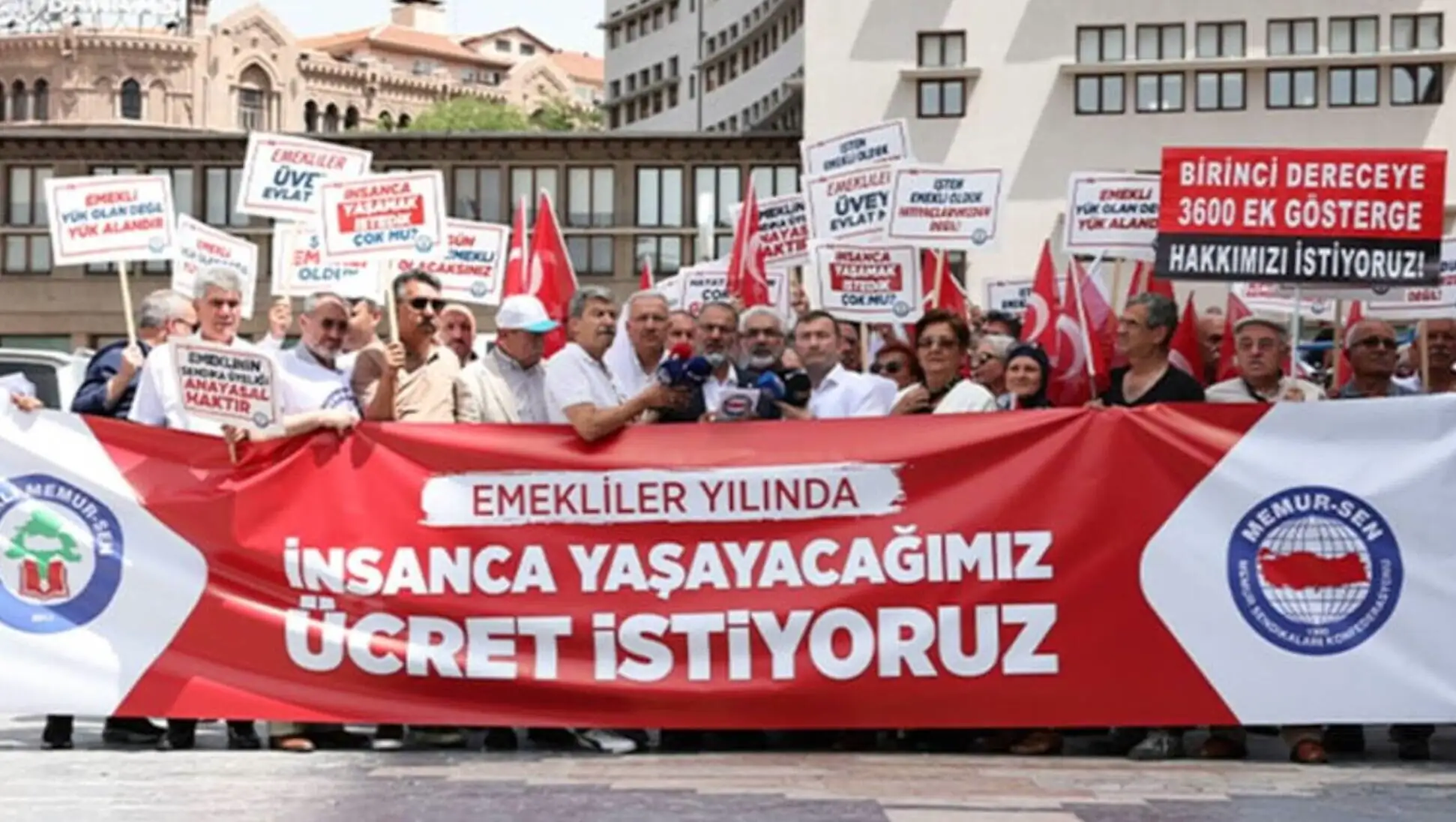 A group of people holding signs and a banner.