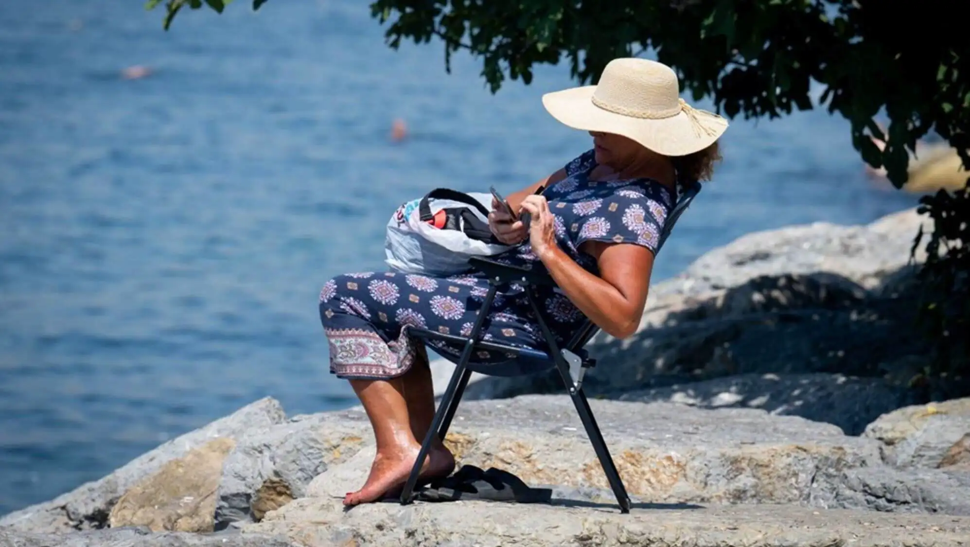 A woman sitting by the water.