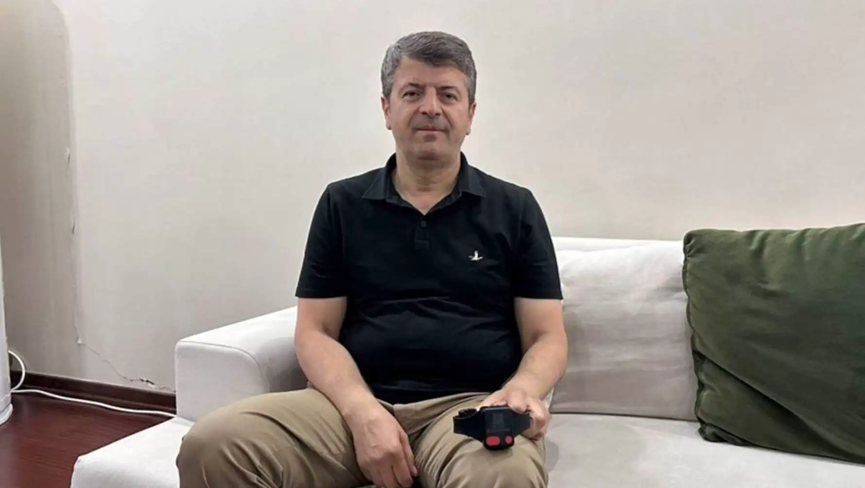 A man sitting on a couch holding a video game controller. A man sitting on a couch holding a video game controller.