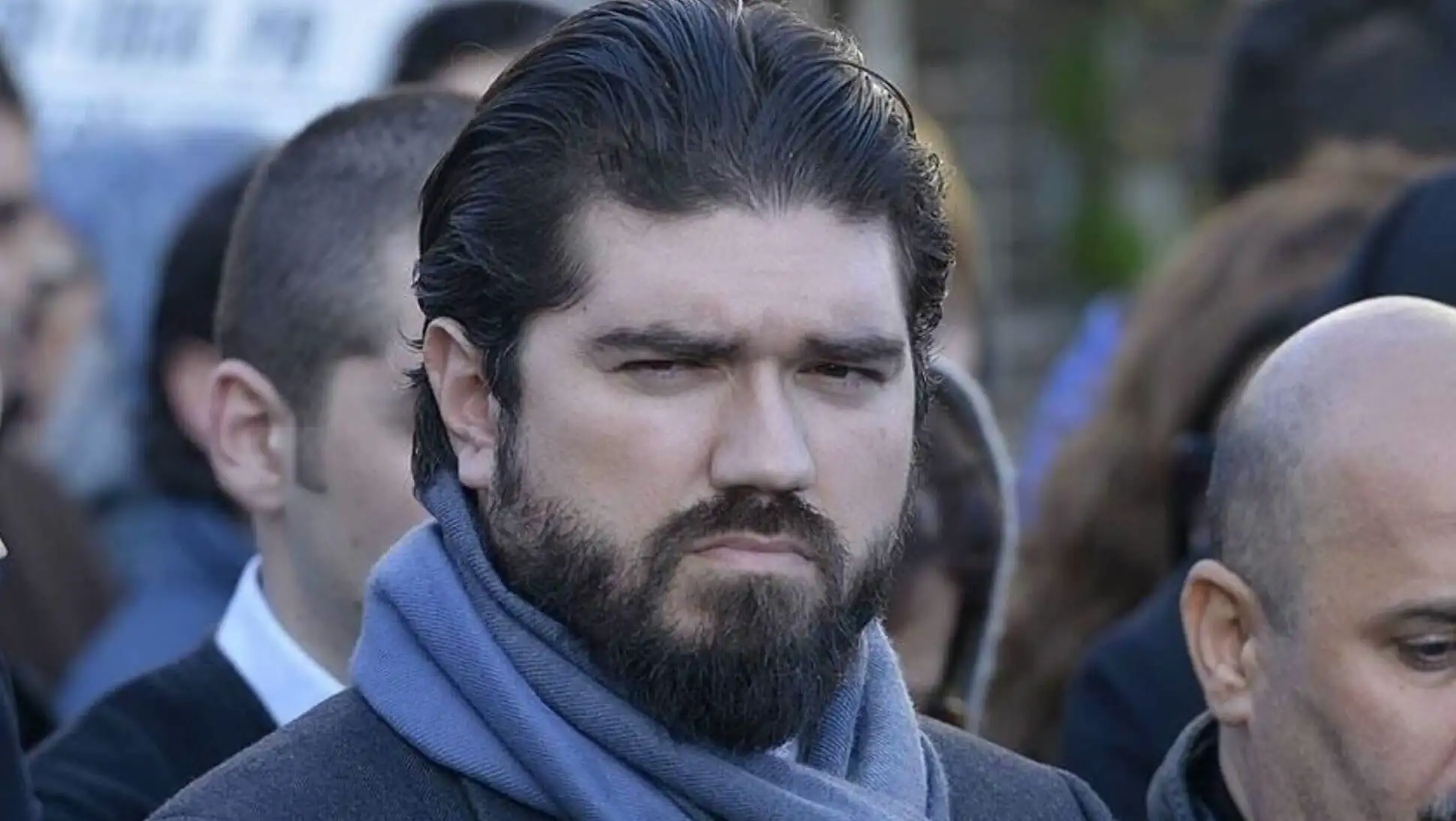Bir adam sakallı ve atkı takmış.