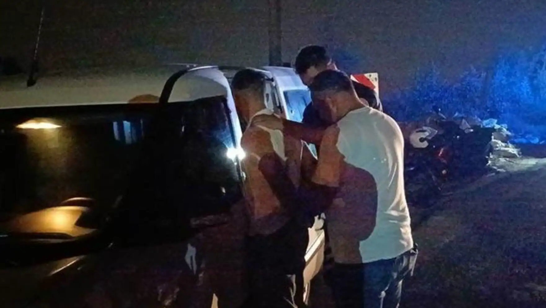 Bir grup adam bir vanın yanında duruyor.