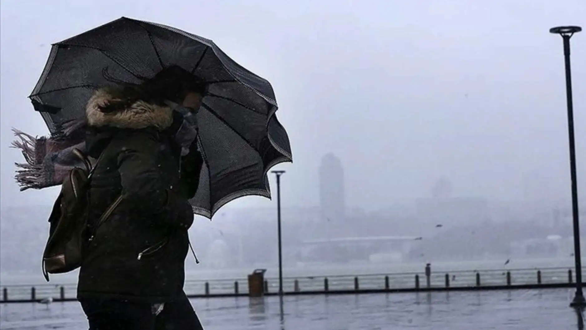 A person walking with an umbrella in the rain. A person walking with an umbrella in the rain.