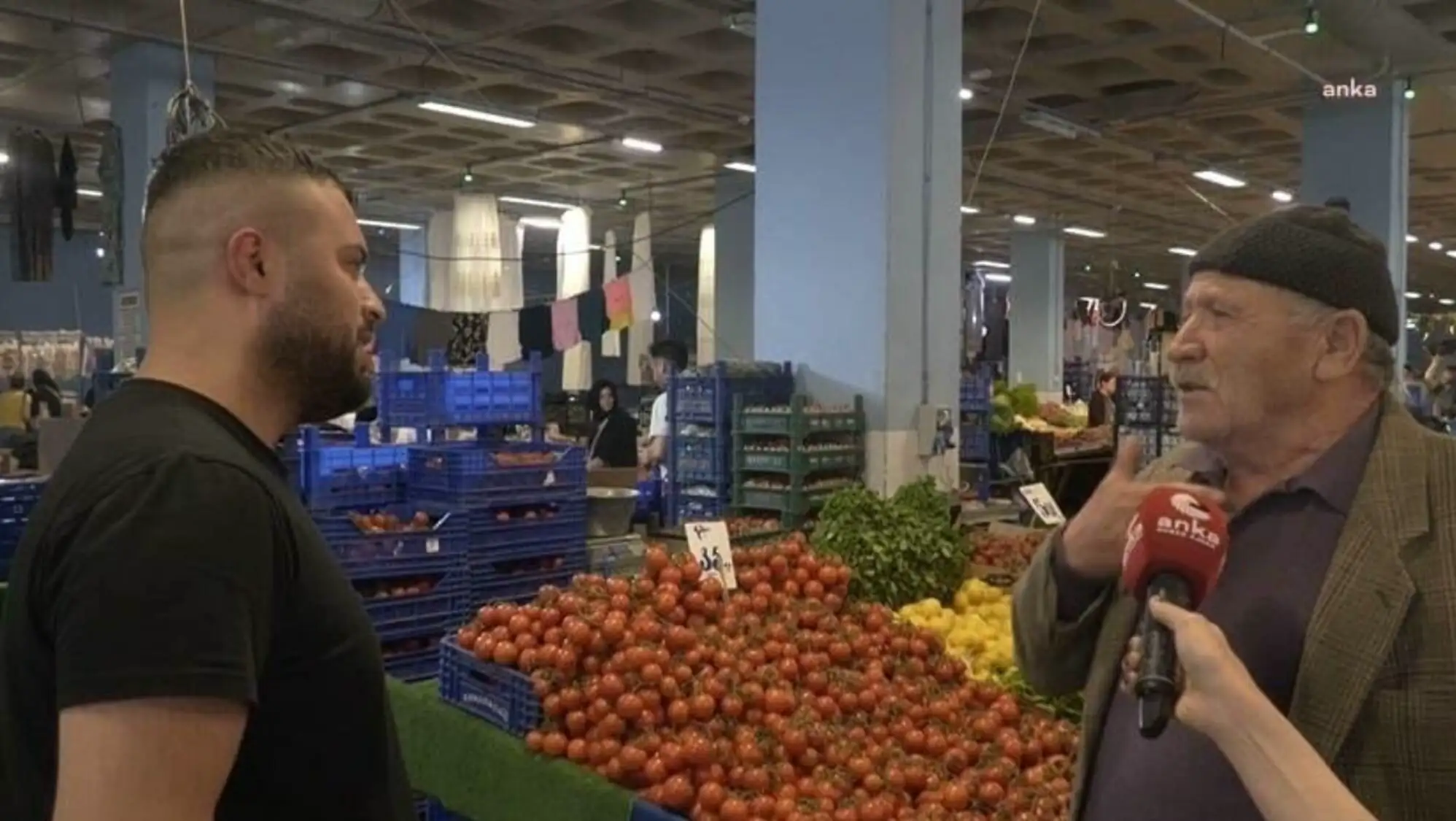 A man talking to another man in a fruit market. A man talking to another man in a fruit market.