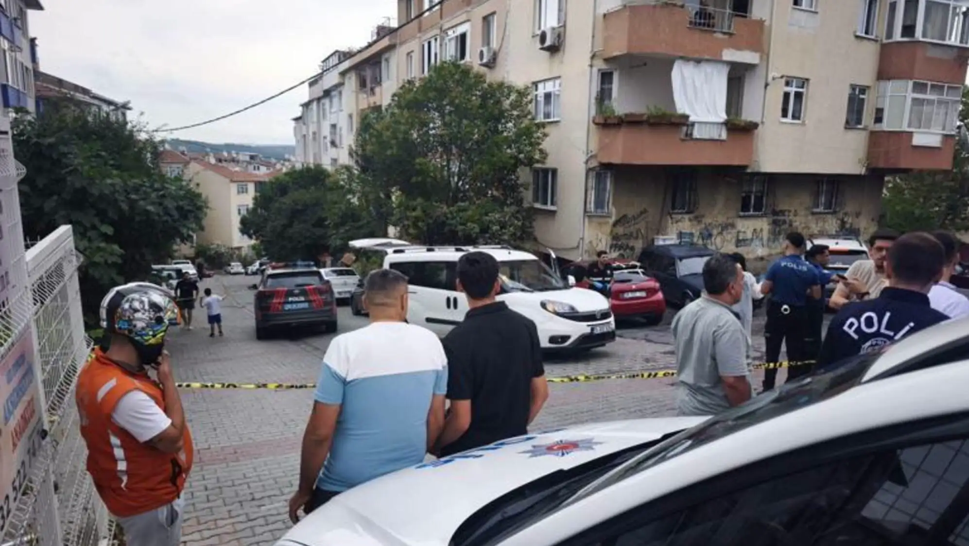 Bir grup insan bir binanın önünde duruyor.