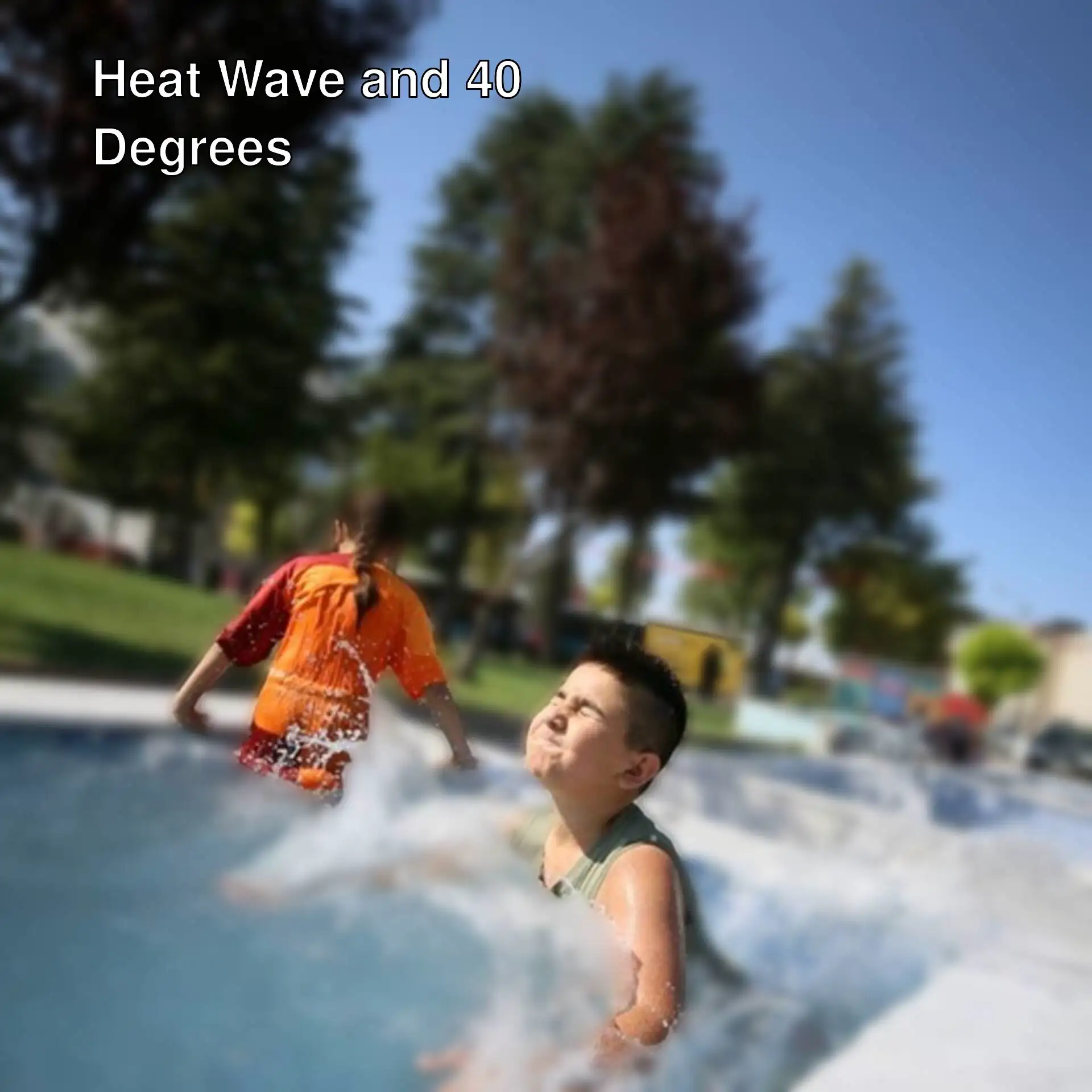 A boy splashing water in a pool.