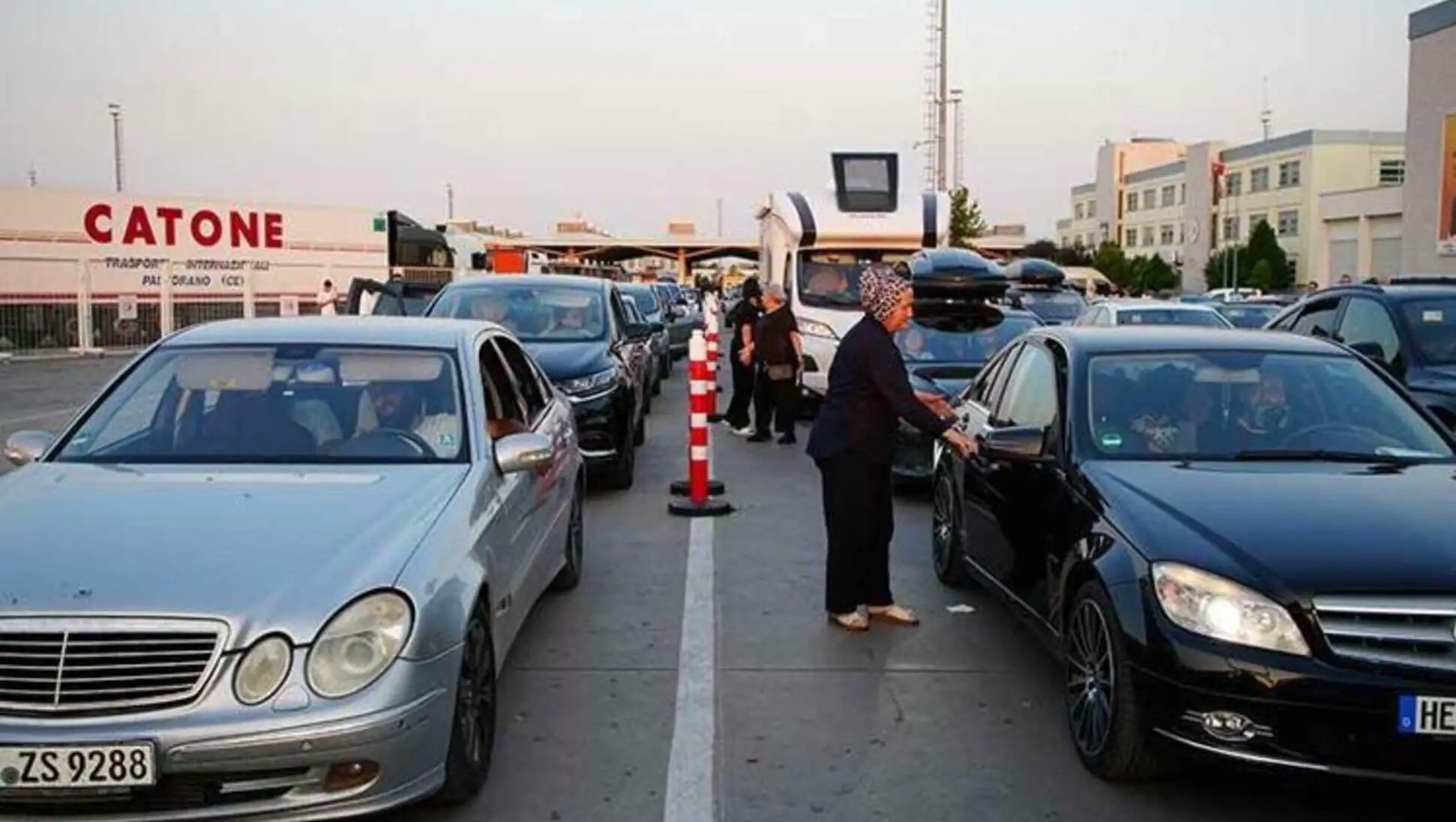 A woman standing next to a row of cars. A woman standing next to a row of cars.