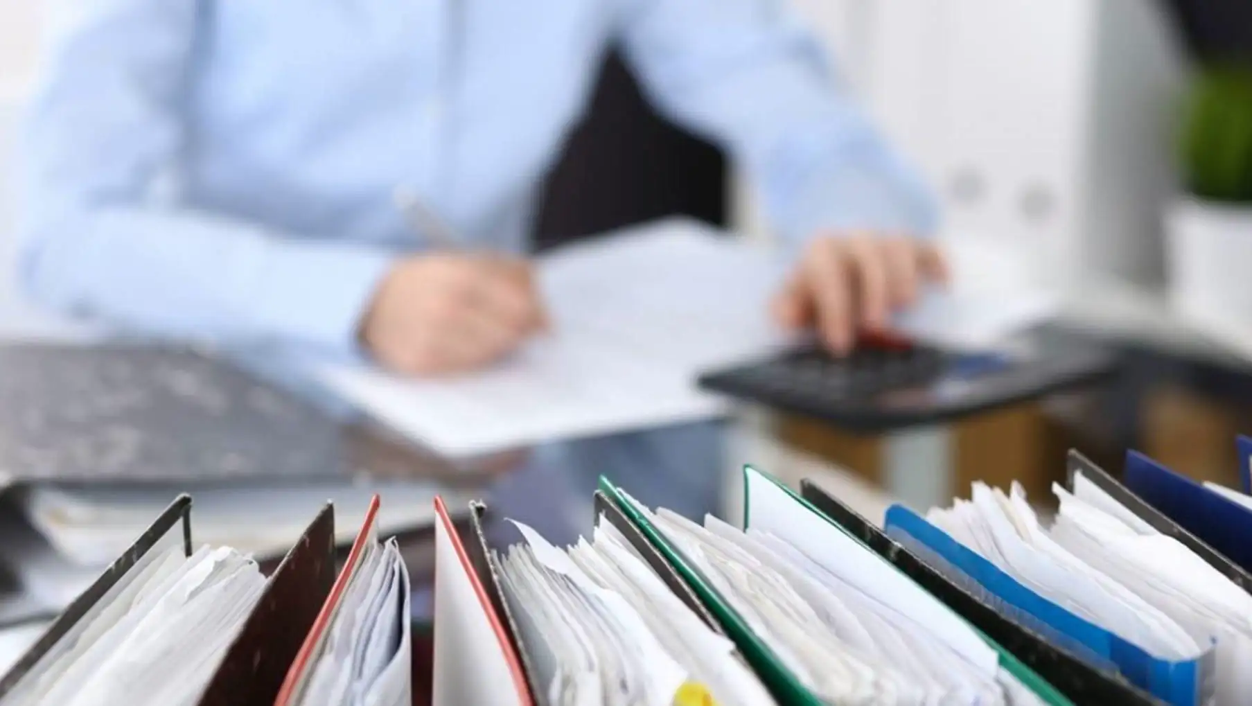 A person working on a calculator. A person working on a calculator.