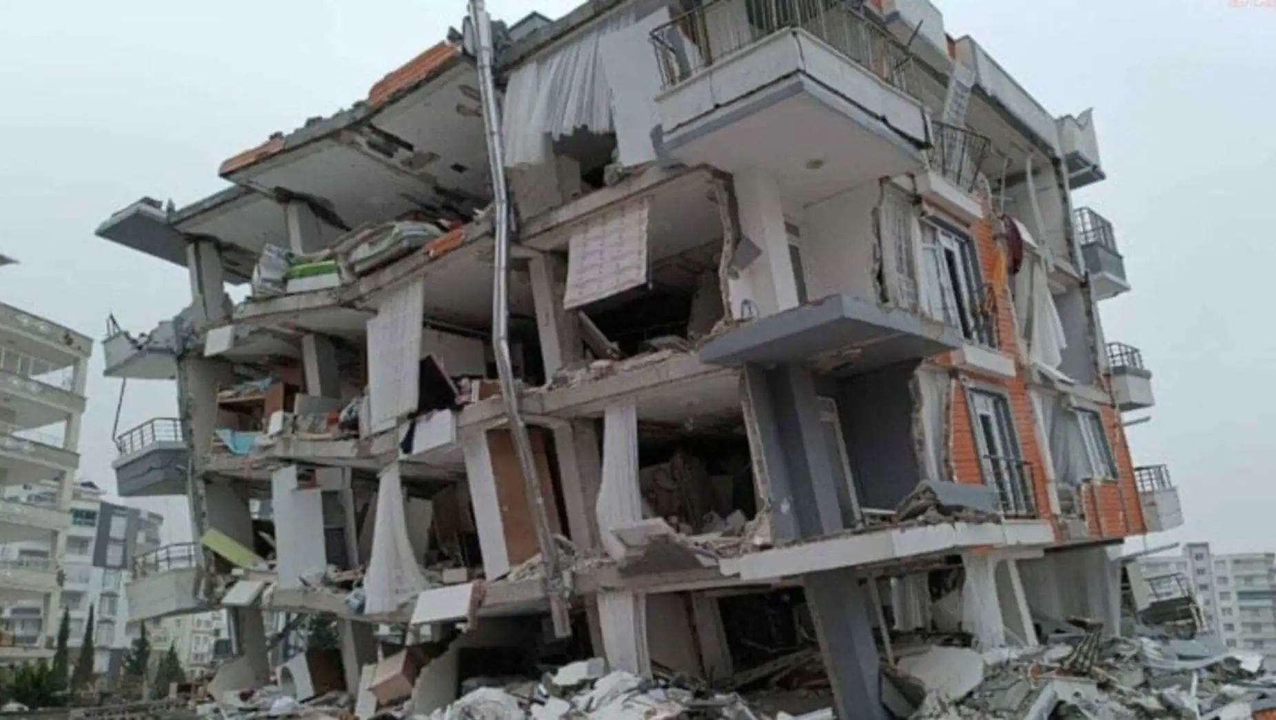 A group of people in uniforms looking at a collapsed building.
