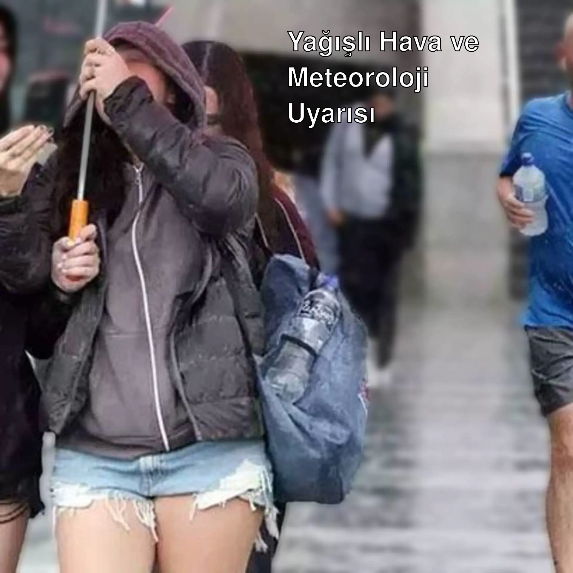 Yağmurda yürüyen bir grup insan.