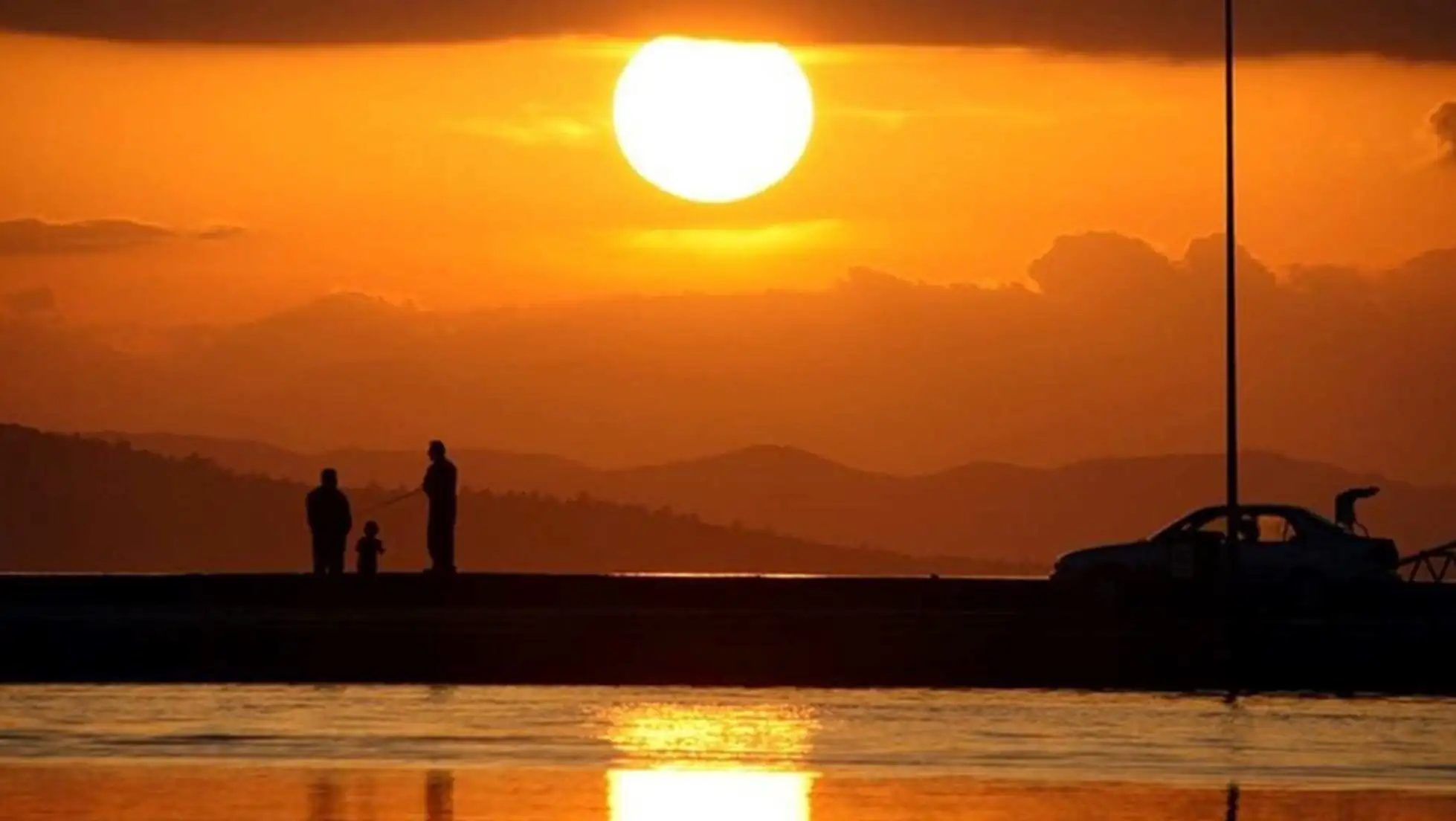 A group of people fishing at sunset.