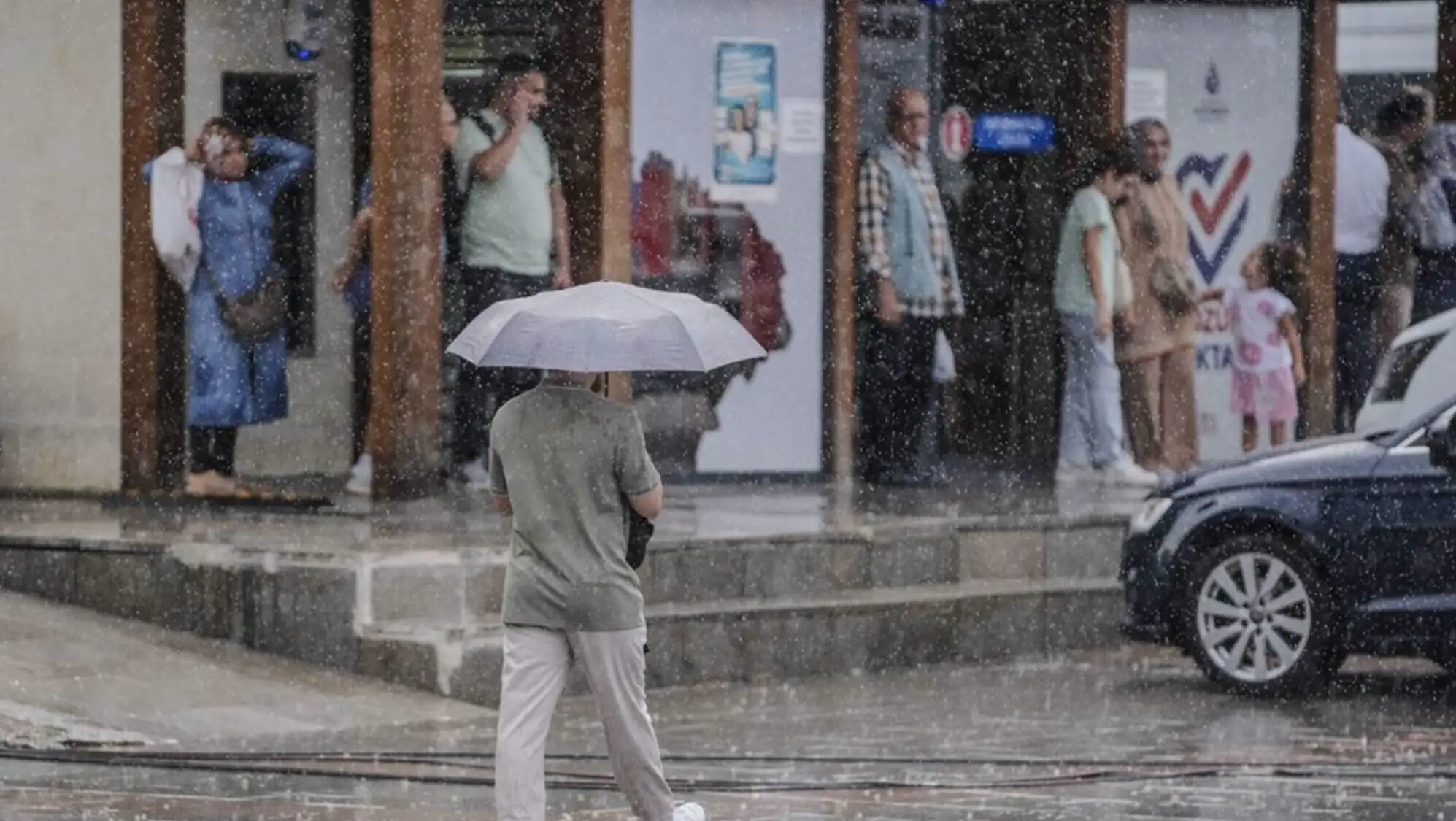 A person holding an umbrella in the rain.