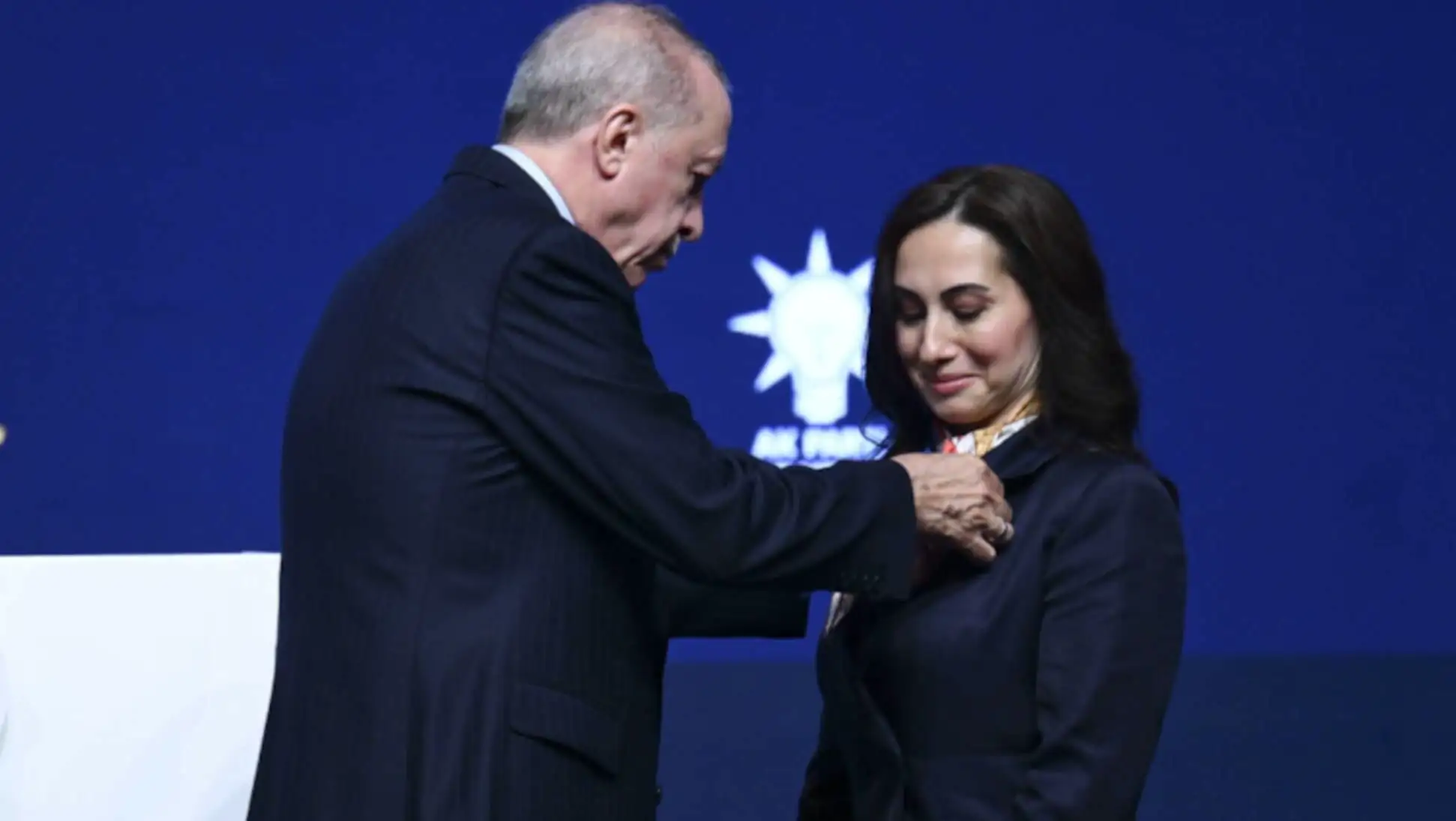A man putting on a woman's jacket.