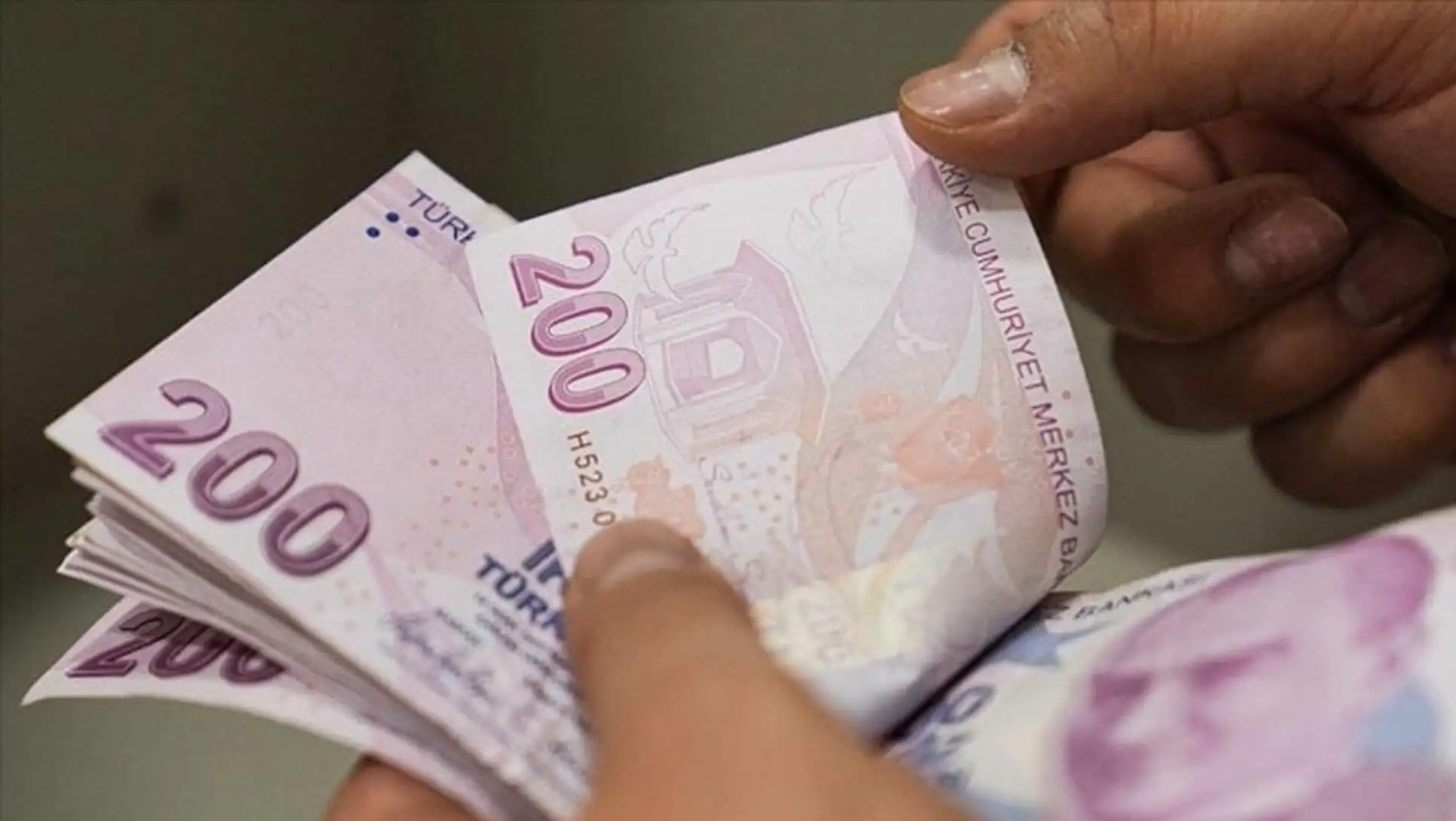 Bir kişi Türk parası tutuyor.