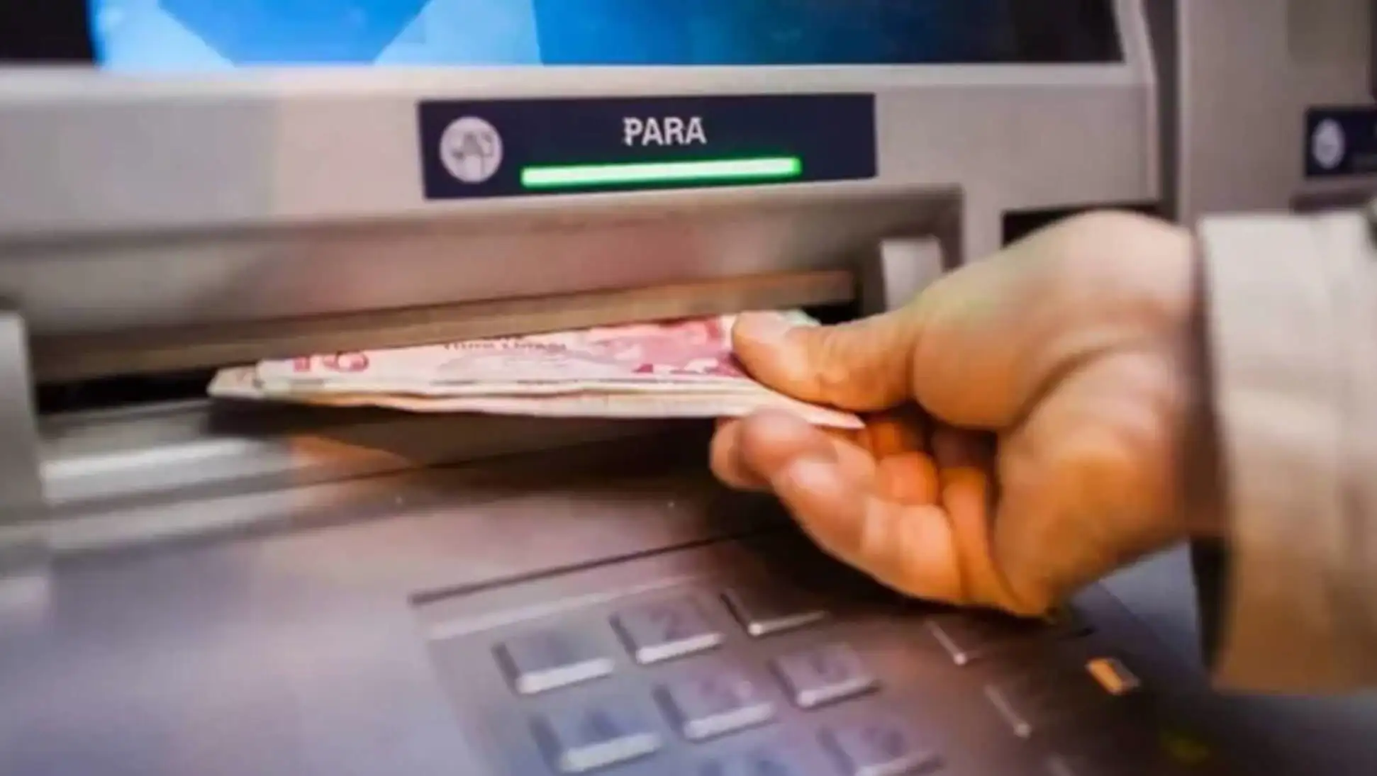 Bir elin ATM'ye para koyması.
