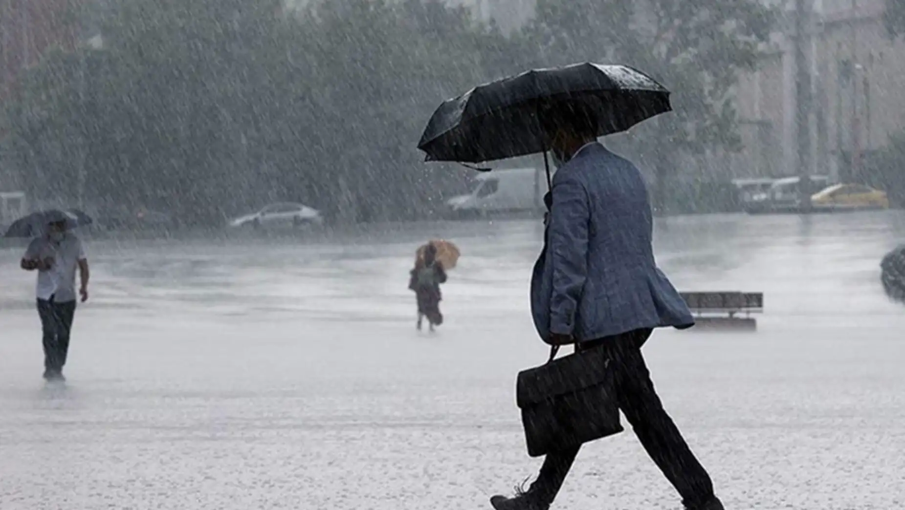 A man walking with an umbrella in the rain.