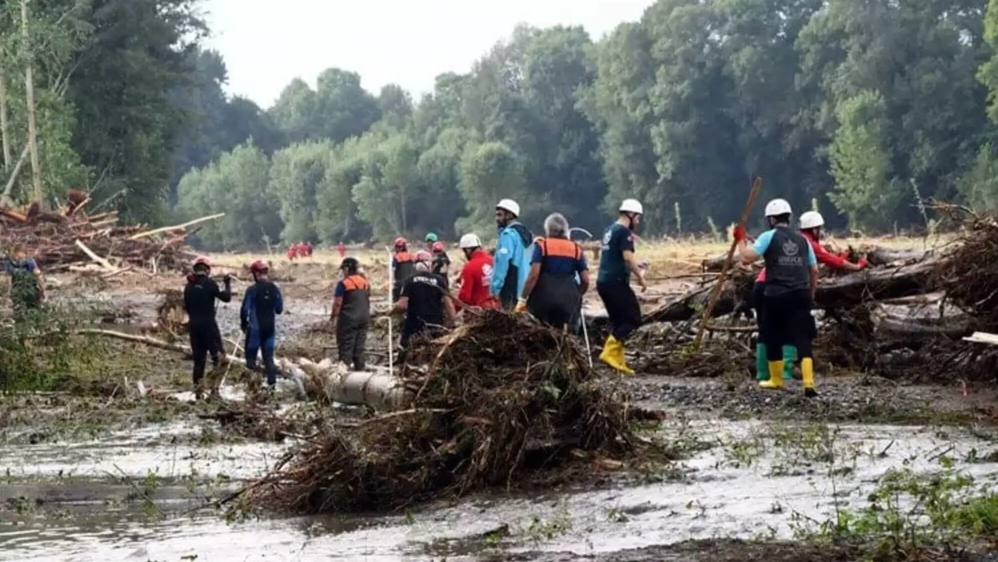 A group of people standing in a muddy area. A group of people standing in a muddy area.