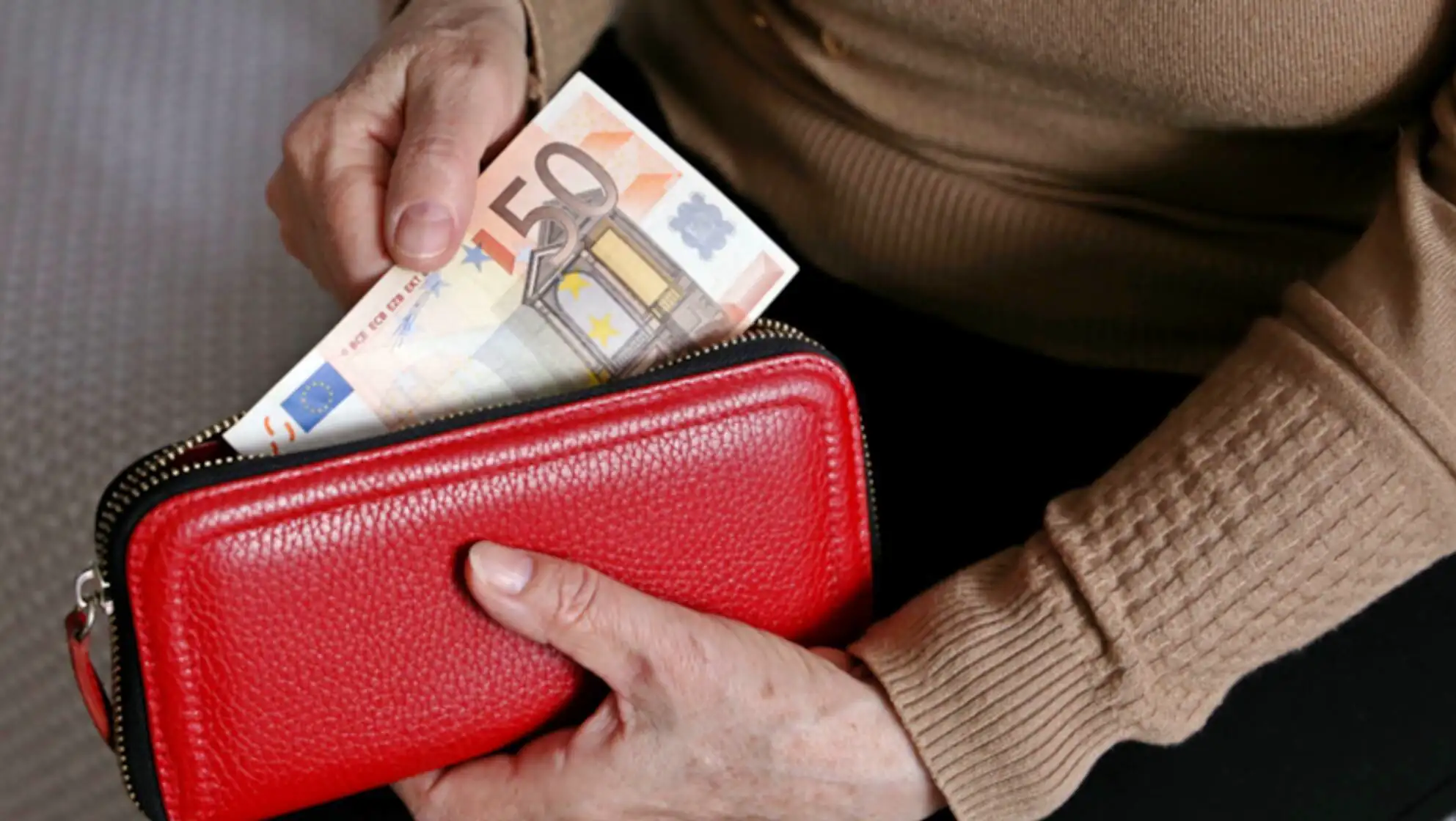 A person putting money in a wallet. A person putting money in a wallet.