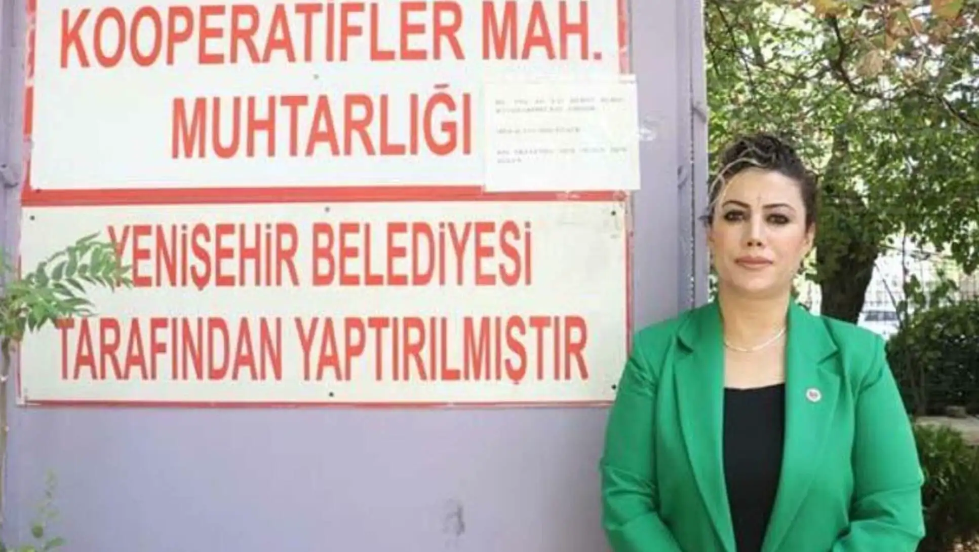 Duvara yaslanmış yeşil ceket giymiş bir kadın Duvara yaslanmış yeşil ceket giymiş bir kadın