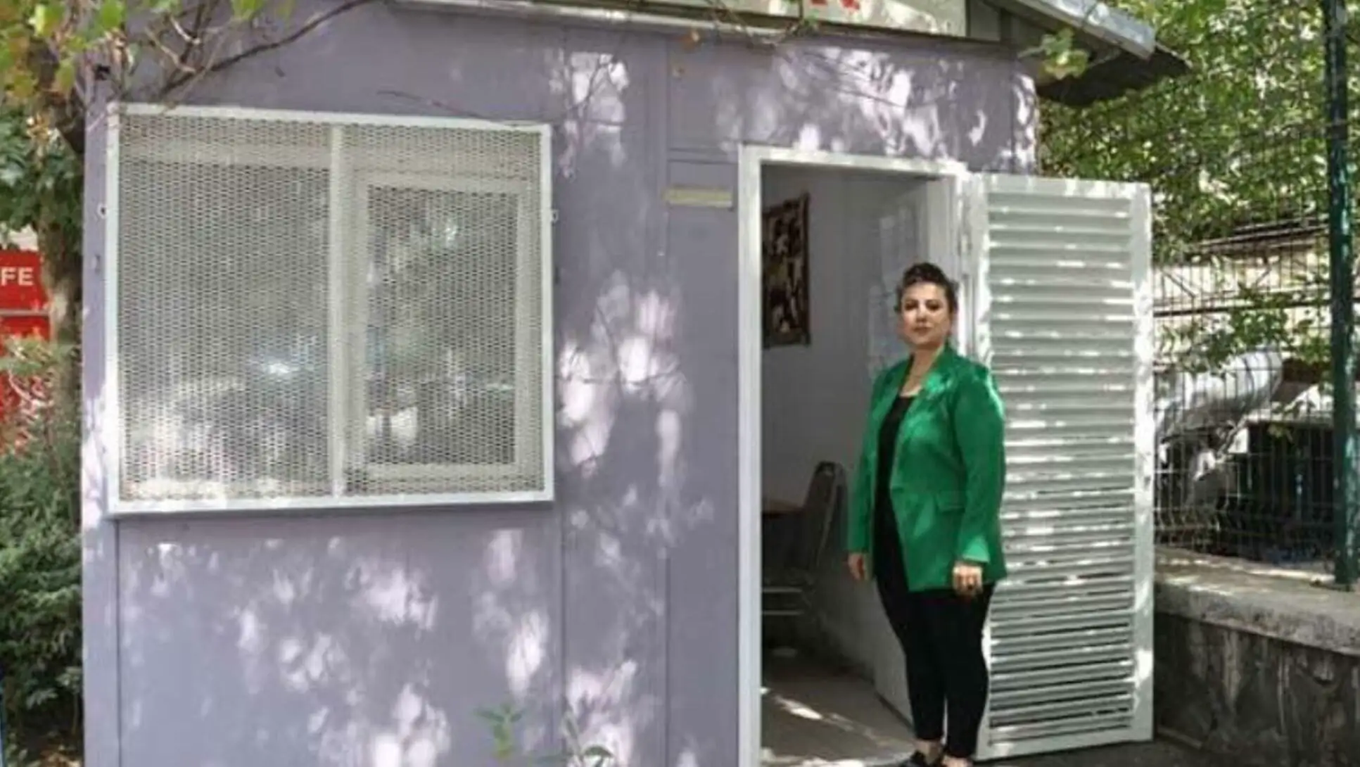 Küçük bir binada duran bir kadın Küçük bir binada duran bir kadın