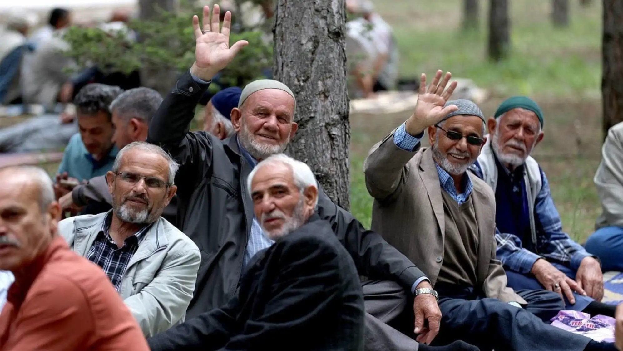 Bir grup adam battaniyelerin üzerinde oturuyor. Bir grup adam battaniyelerin üzerinde oturuyor.