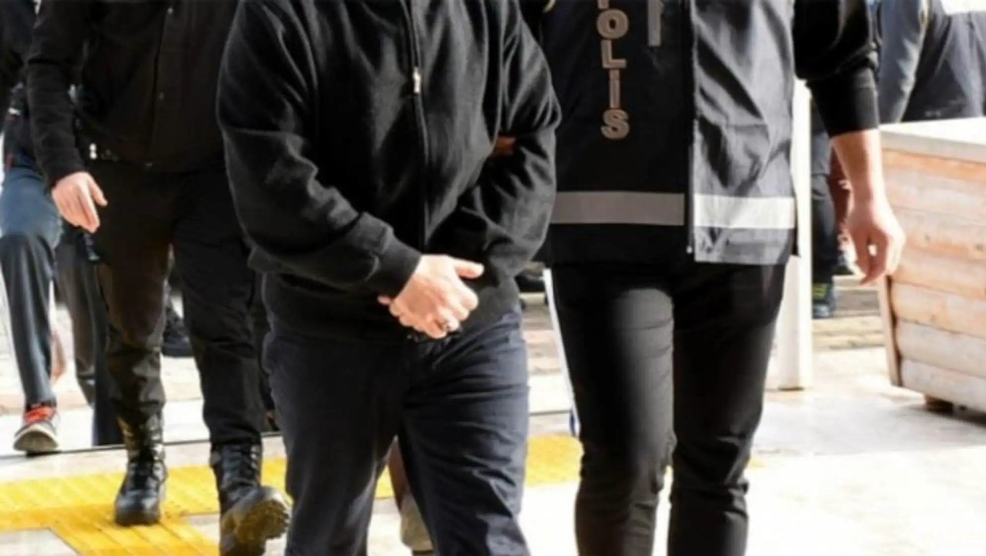 A man in a black jacket walking with a police officer during the Yolyemezler gang operation. A man in a black jacket walking with a police officer during the Yolyemezler gang operation.