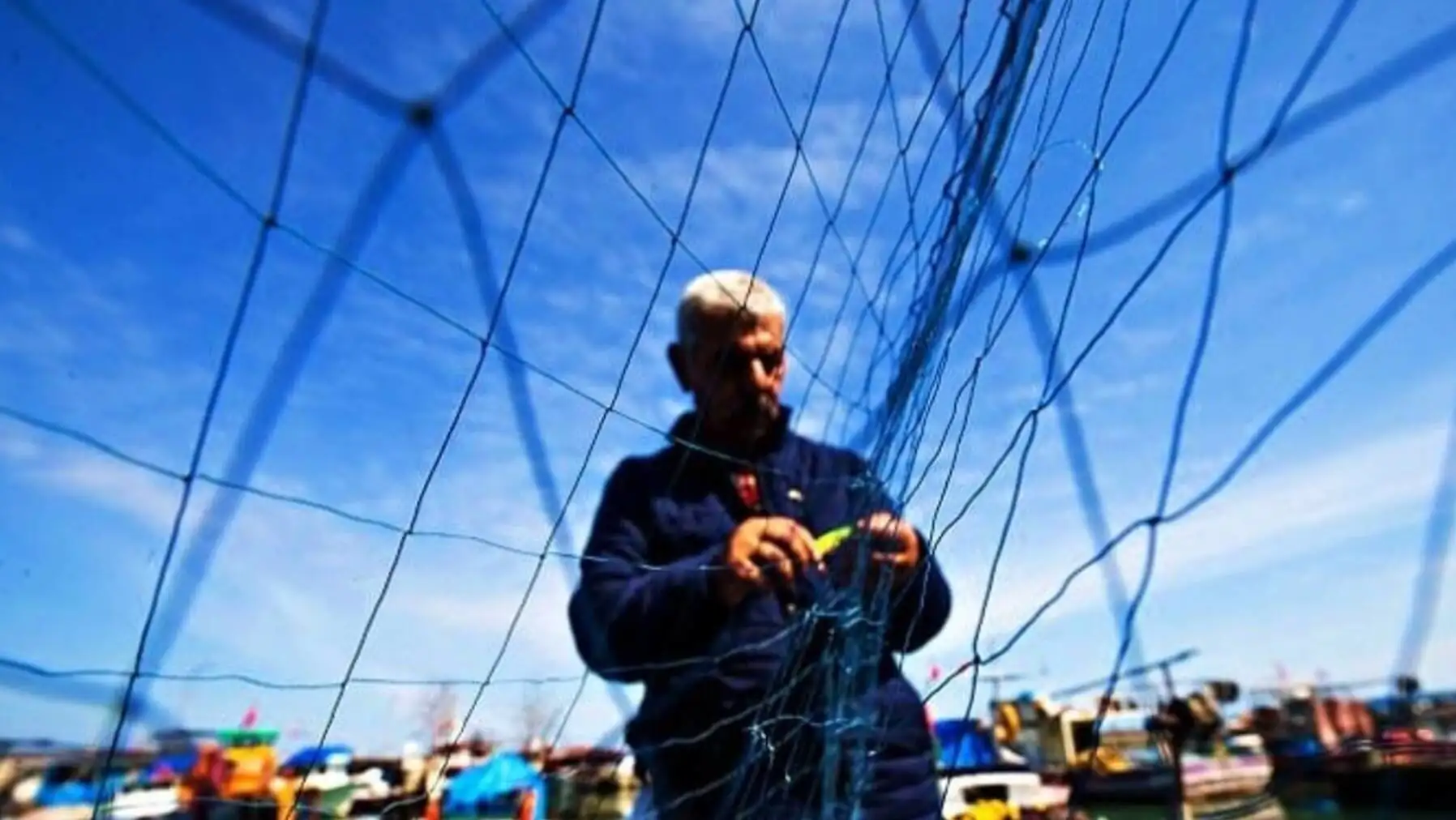 A man cutting a net. A man cutting a net.