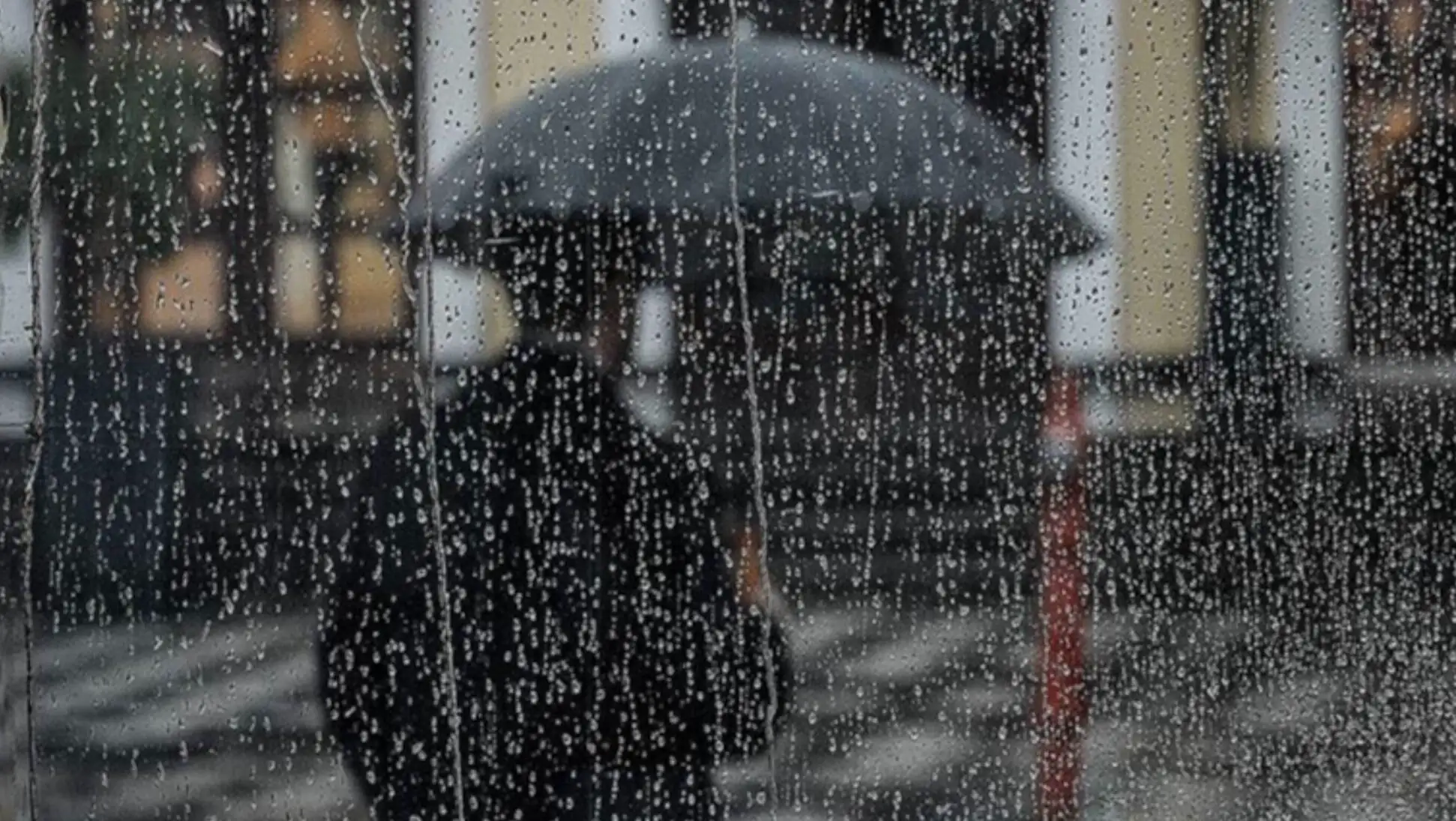A person holding an umbrella in the rain. A person holding an umbrella in the rain.
