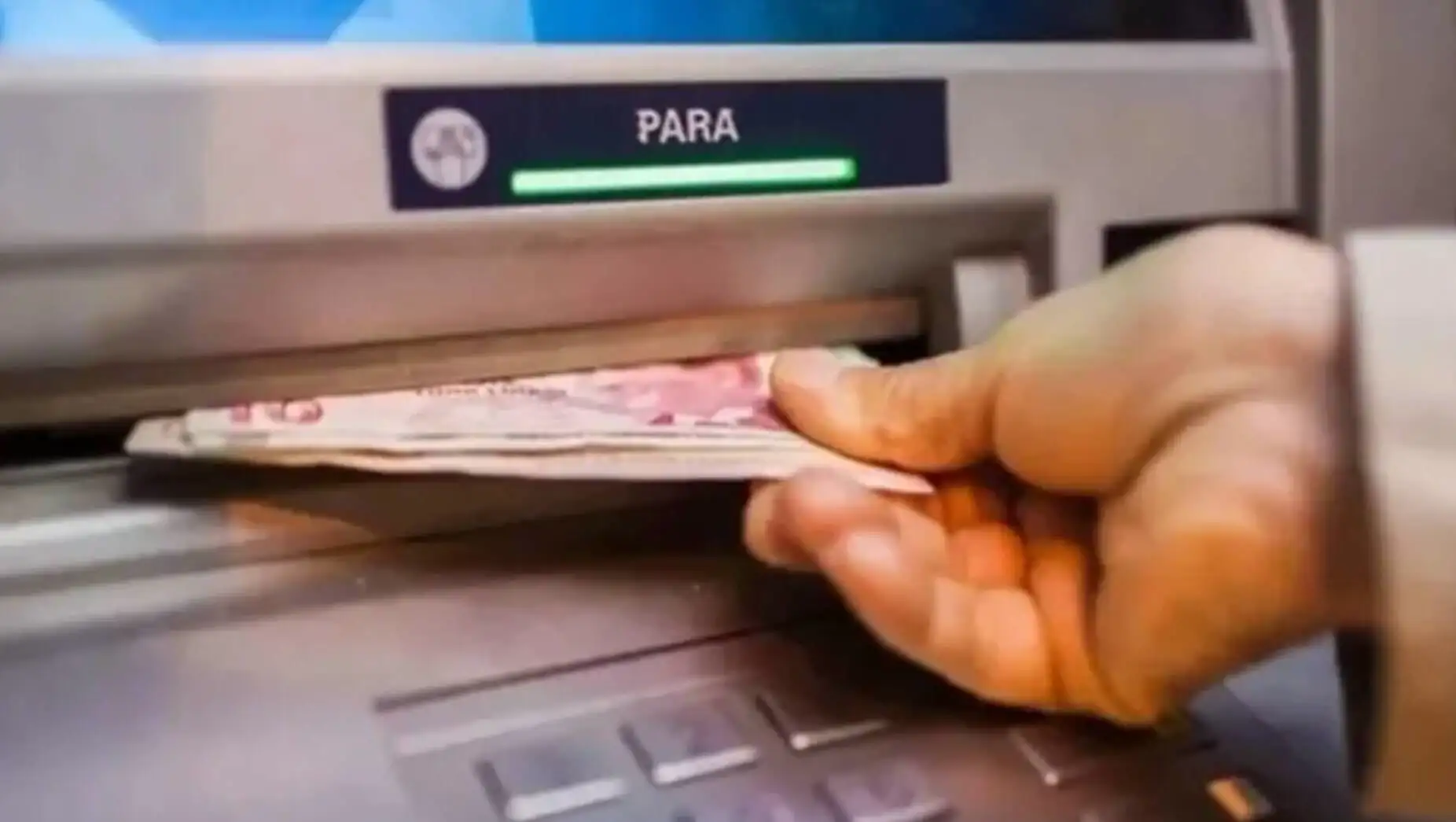 Bir el ATM'ye para koyuyor. Bir el ATM'ye para koyuyor.