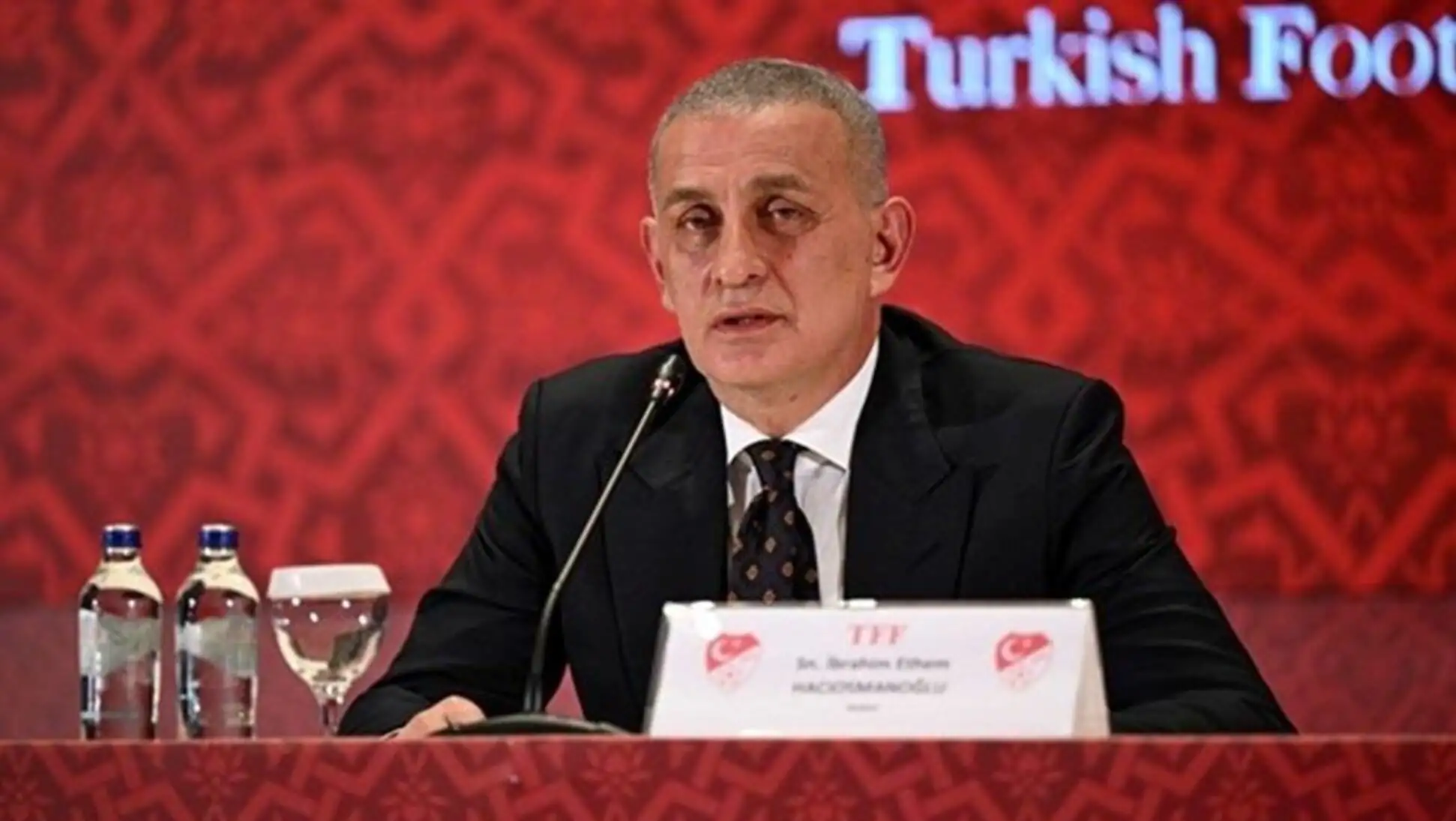 Bir adam bir podiumda oturuyor.