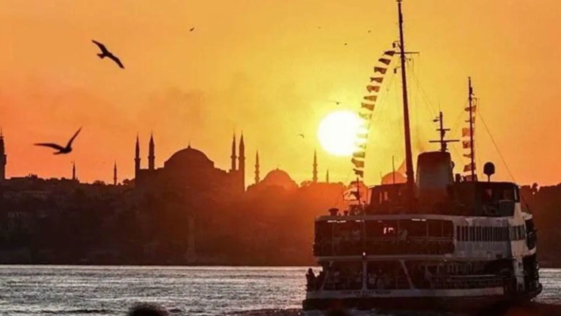 Bir bot su üzerinde, arka planda bir şehir.