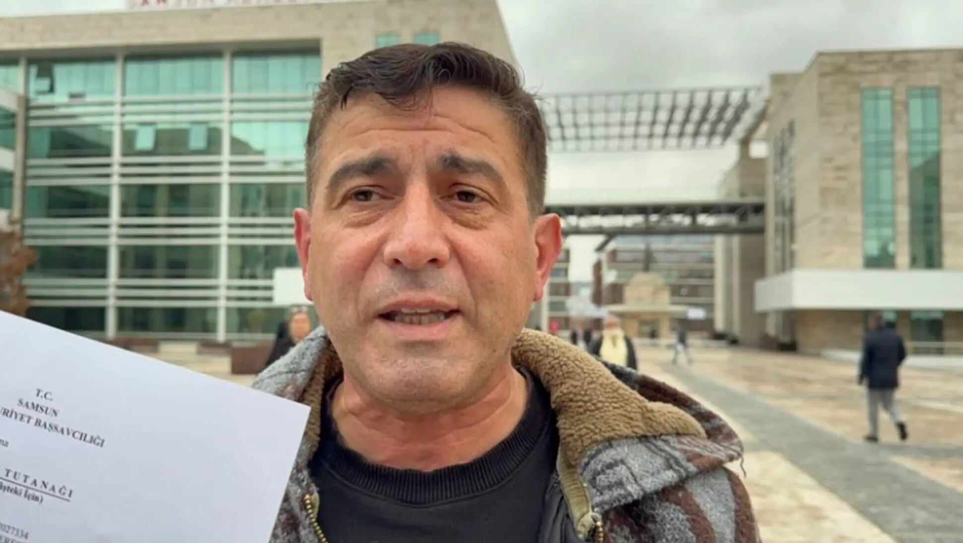 A man holding a piece of paper. A man holding a piece of paper.