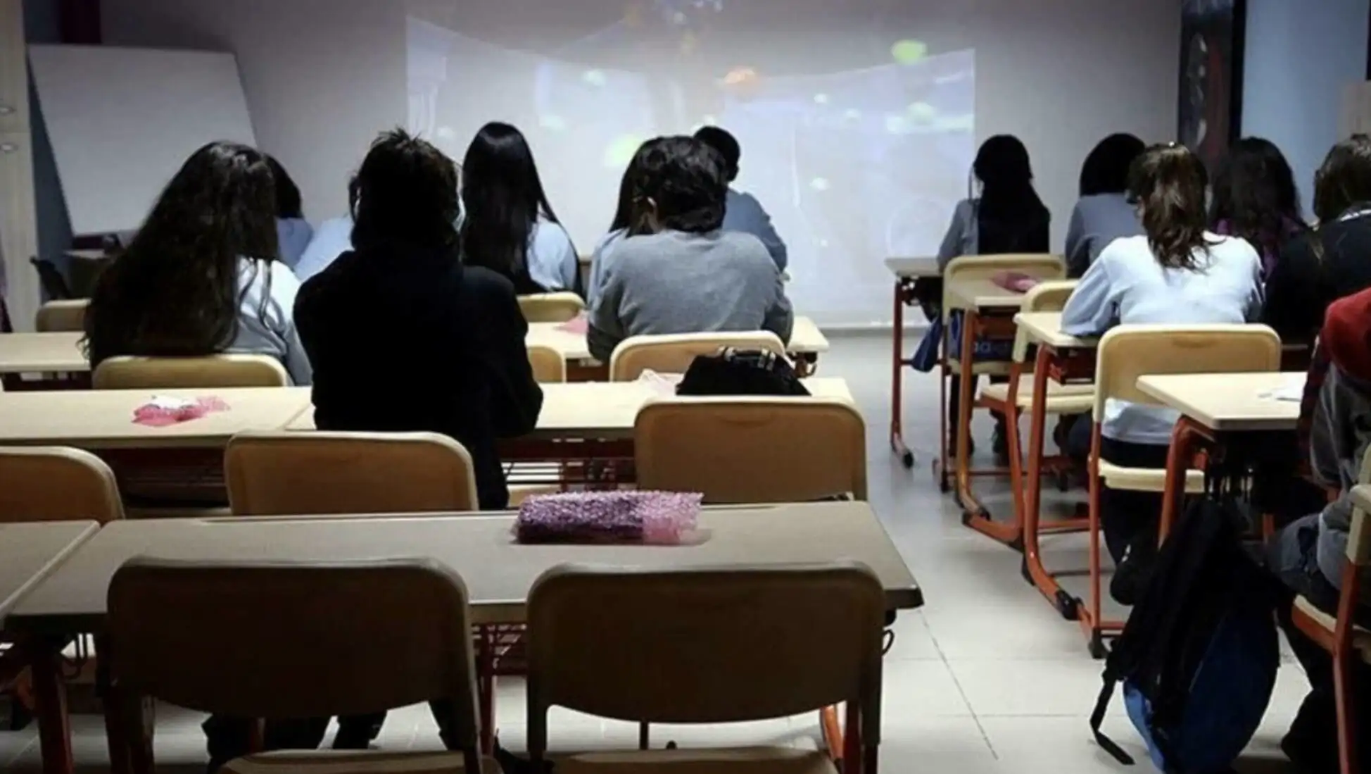 A group of people sitting in a classroom, indicating the impact of weather on education. A group of people sitting in a classroom, indicating the impact of weather on education.