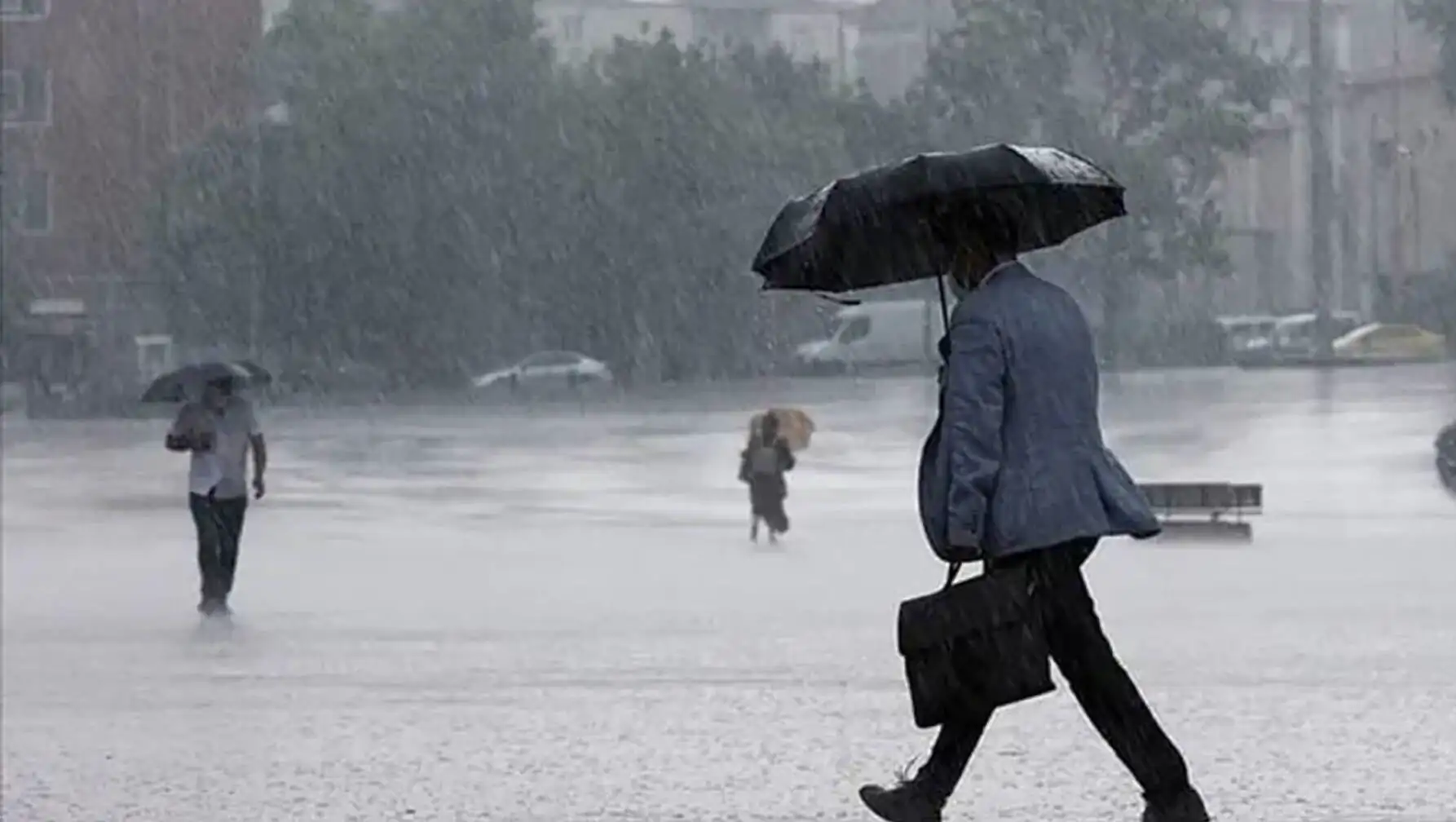 A man walking in the rain with an umbrella. A man walking in the rain with an umbrella.