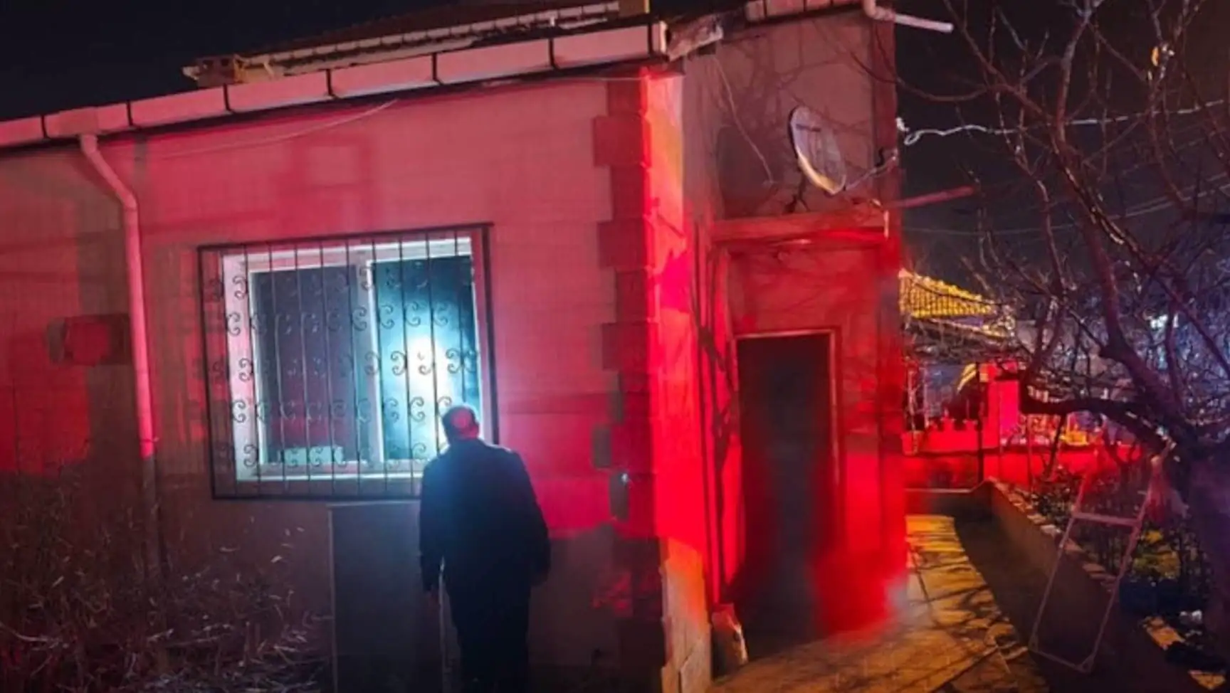 Yangın sonrası evin önünde bekleyen insanlar.