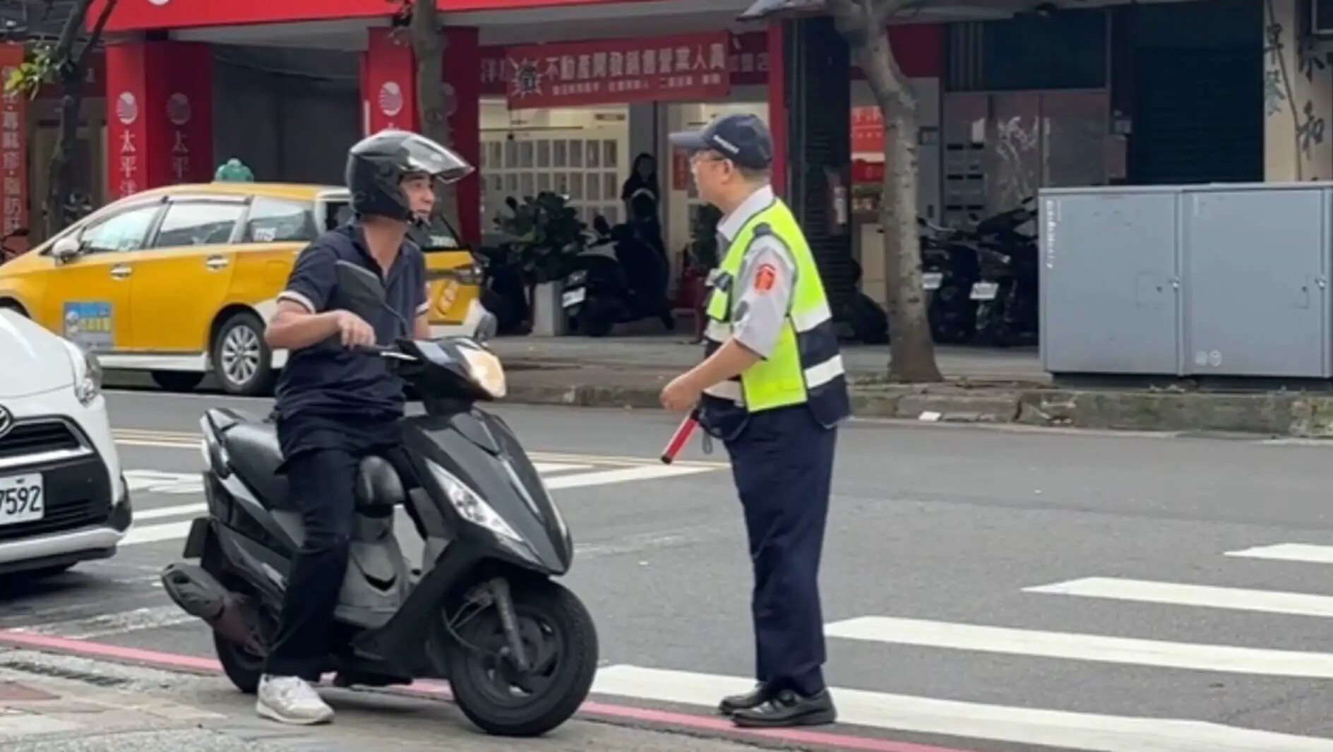 A man on a scooter talking to another man.