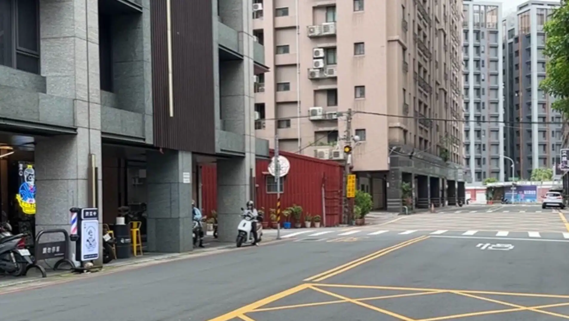 A street view with a scooter and buildings.