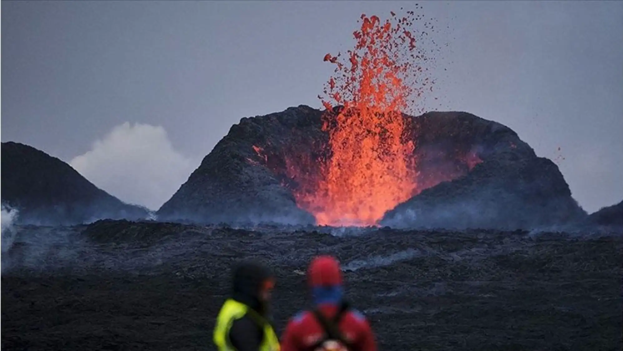 A volcano erupting with lava coming out of the ground.