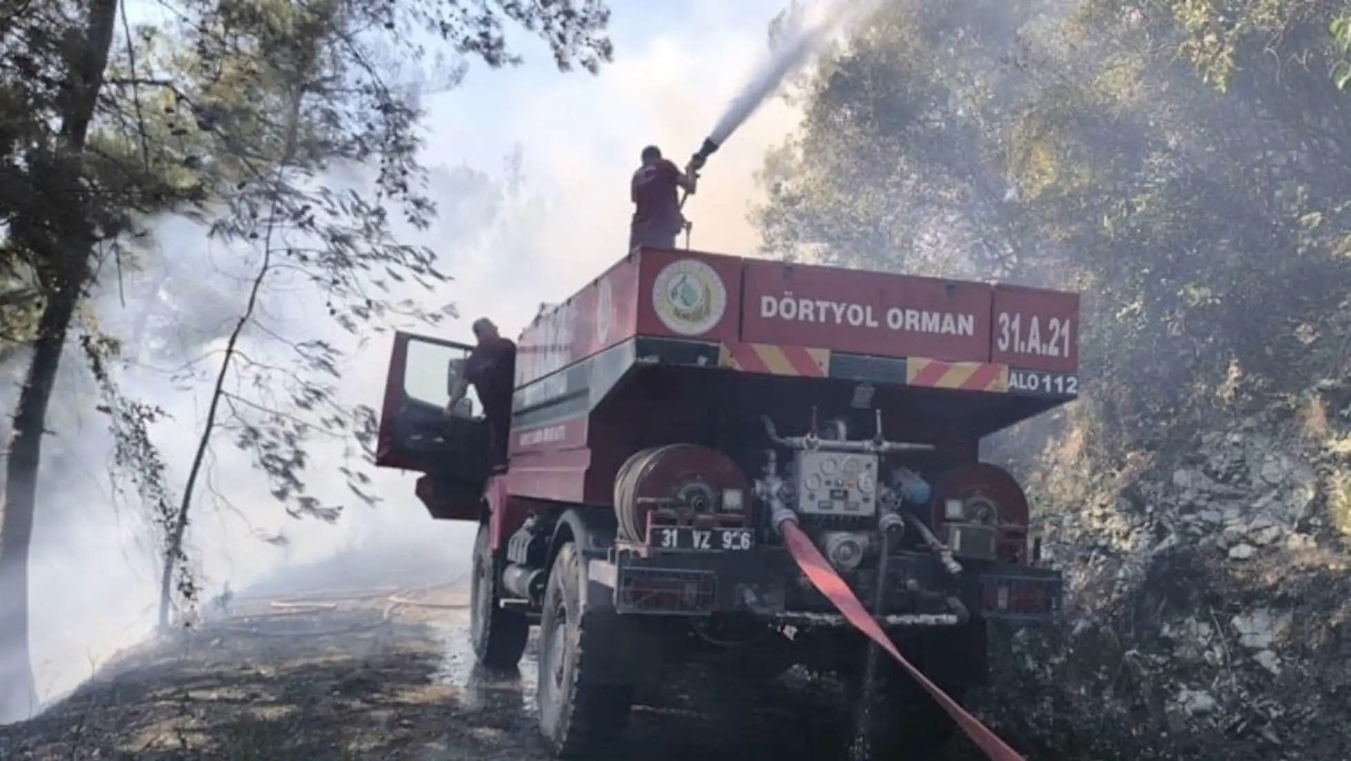 Bir itfaiye aracı orman yangınına müdahale ediyor.