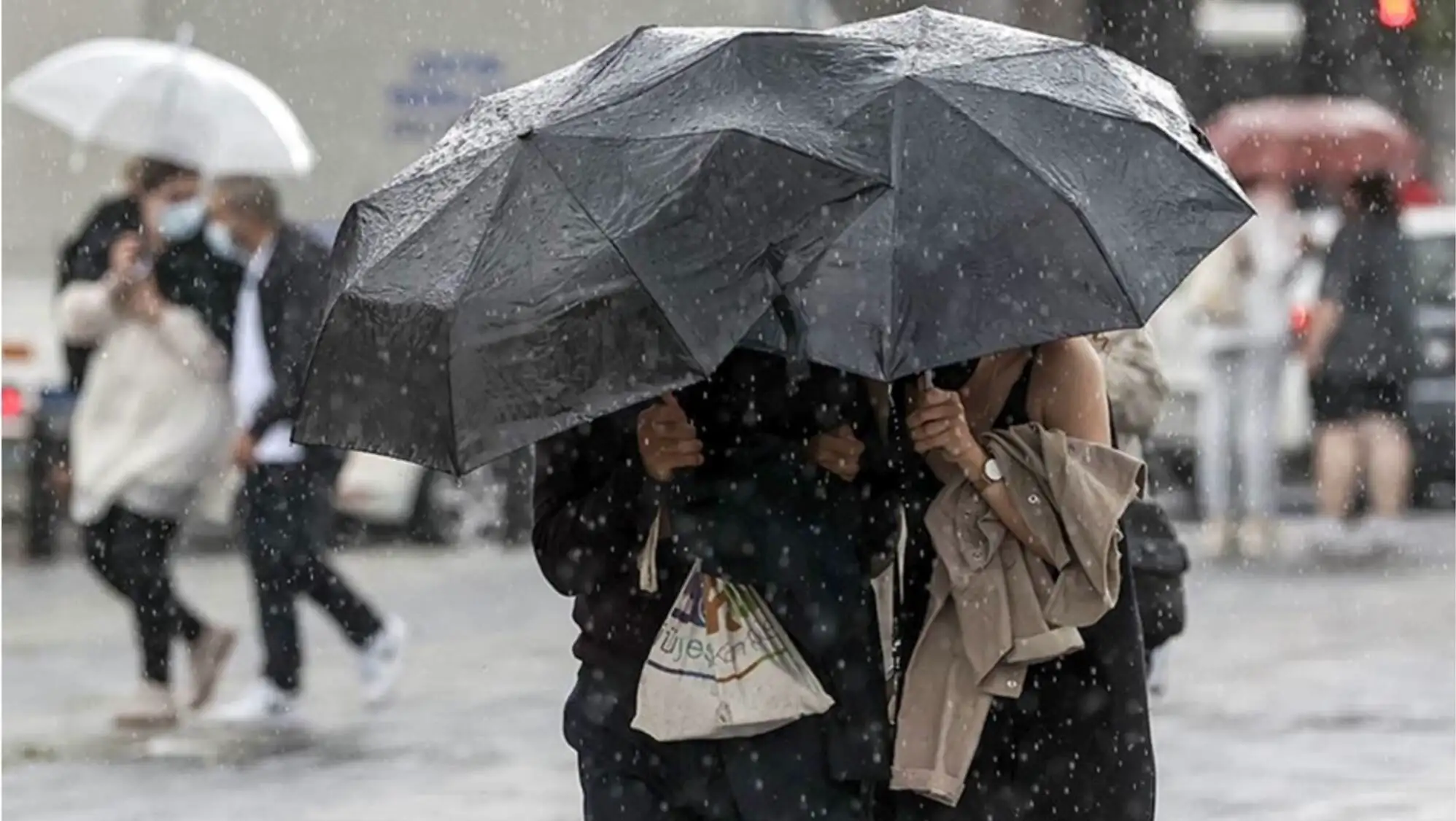 A couple of people under an umbrella in the rain. A couple of people under an umbrella in the rain.