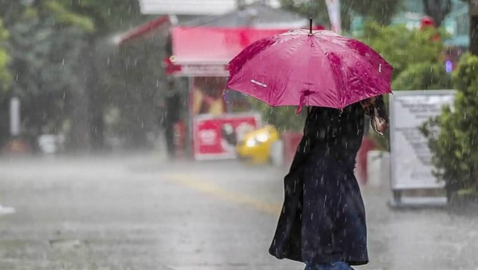 A person walking in the rain with an umbrella. A person walking in the rain with an umbrella.