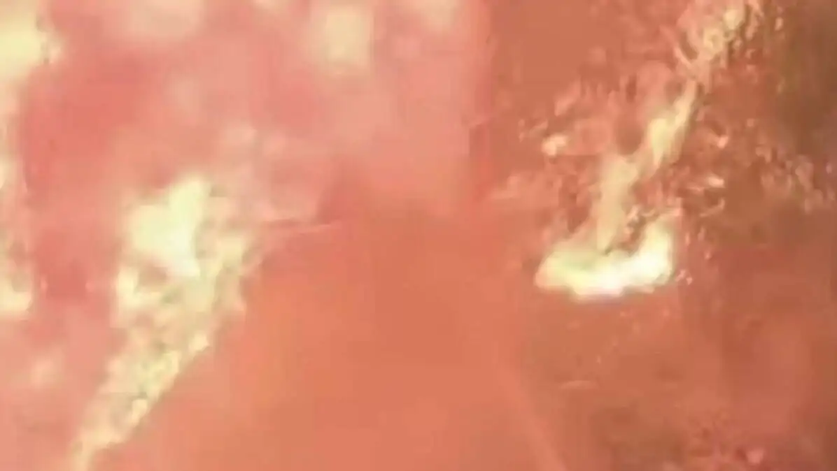 A car with a fire in the background. A car with a fire in the background.
