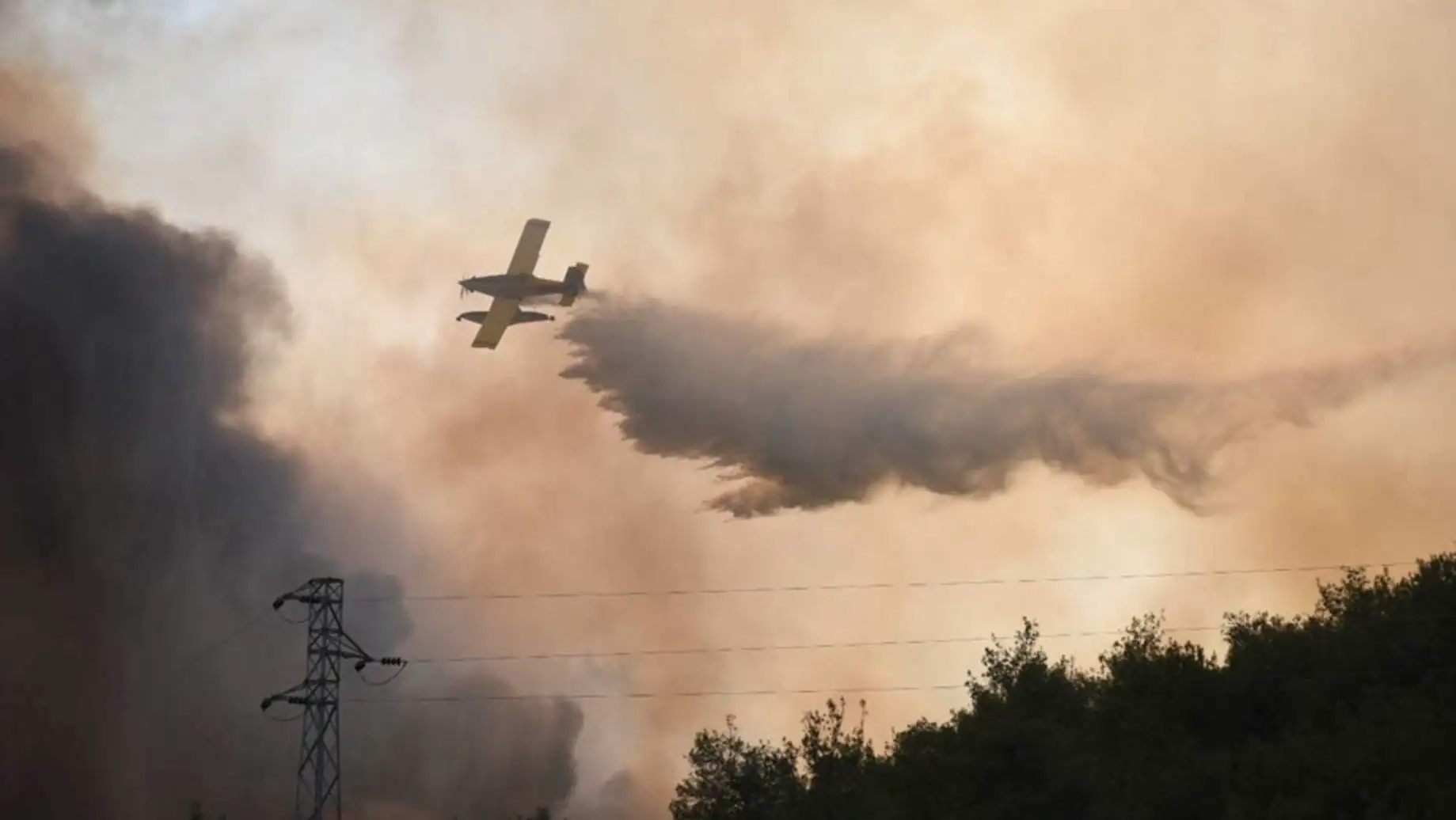 A helicopter dropping water on a forest fire.