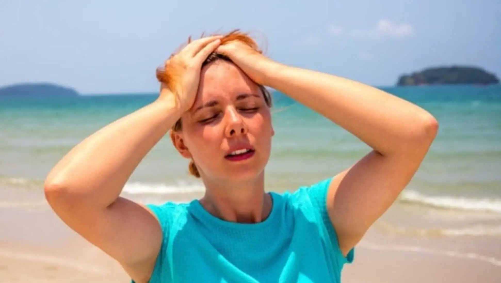 A woman holding her head with her hands. Concerns about climate change.
