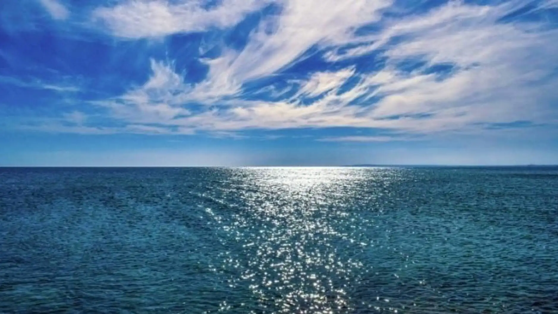 A body of water with a blue sky and clouds. Effects of climate change.