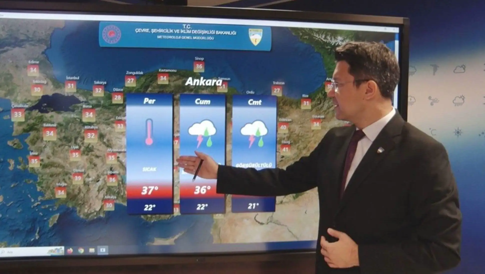 Bir adam takım elbise giymiş, büyük bir ekranda hava tahminini gösteriyor. Bir adam takım elbise giymiş, büyük bir ekranda hava tahminini gösteriyor.