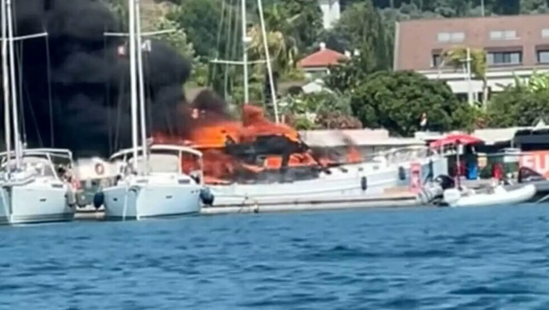 A boat on fire near water.